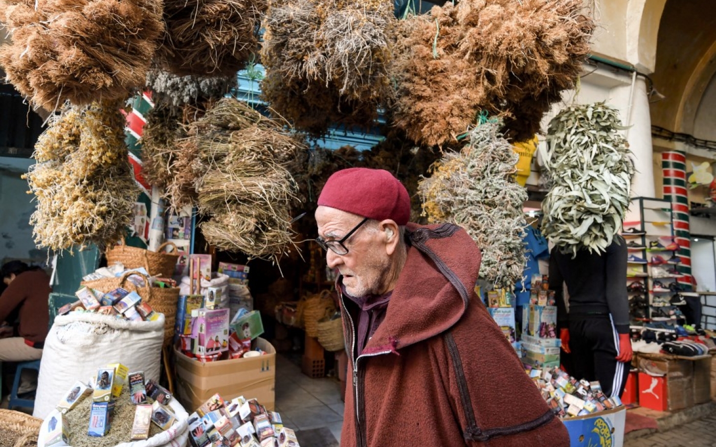 Un client tunisien passe devant une boutique d’herboriste dans le souk El Blat, dans la médina (vieille ville) de Tunis (AFP)