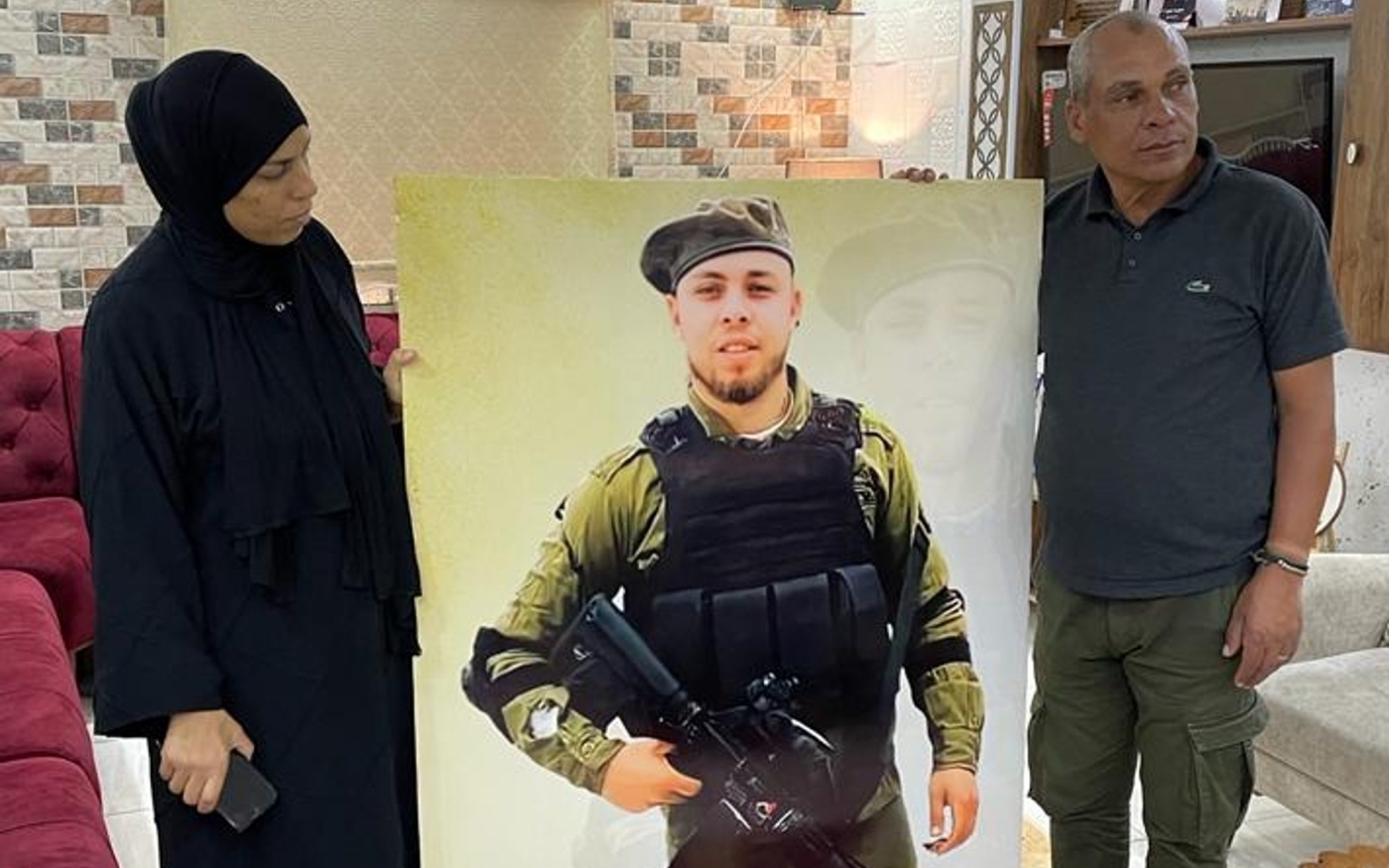Lubna al-Amouri et son mari Mahmoud se tiennent à côté d’une photographie de leur fils, Jamil (MEE)