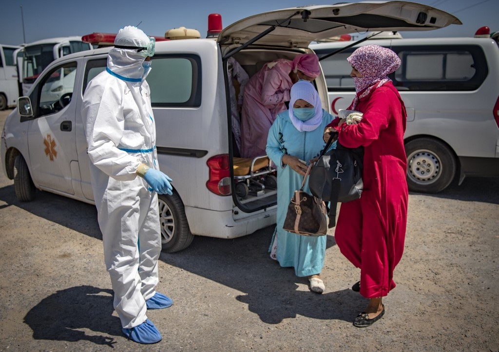 Des Marocaines, testées positives au COVID-19, sont transférées dans un centre médical (AFP)