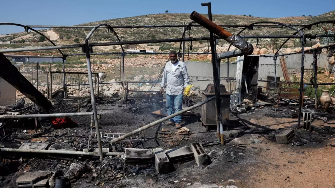 Un Palestinien inspecte une maison incendiée pendant l’attaque du village d’al-Mughayyir par des colons israéliens, en Cisjordanie occupée, le 13 avril 2024 (Reuters)