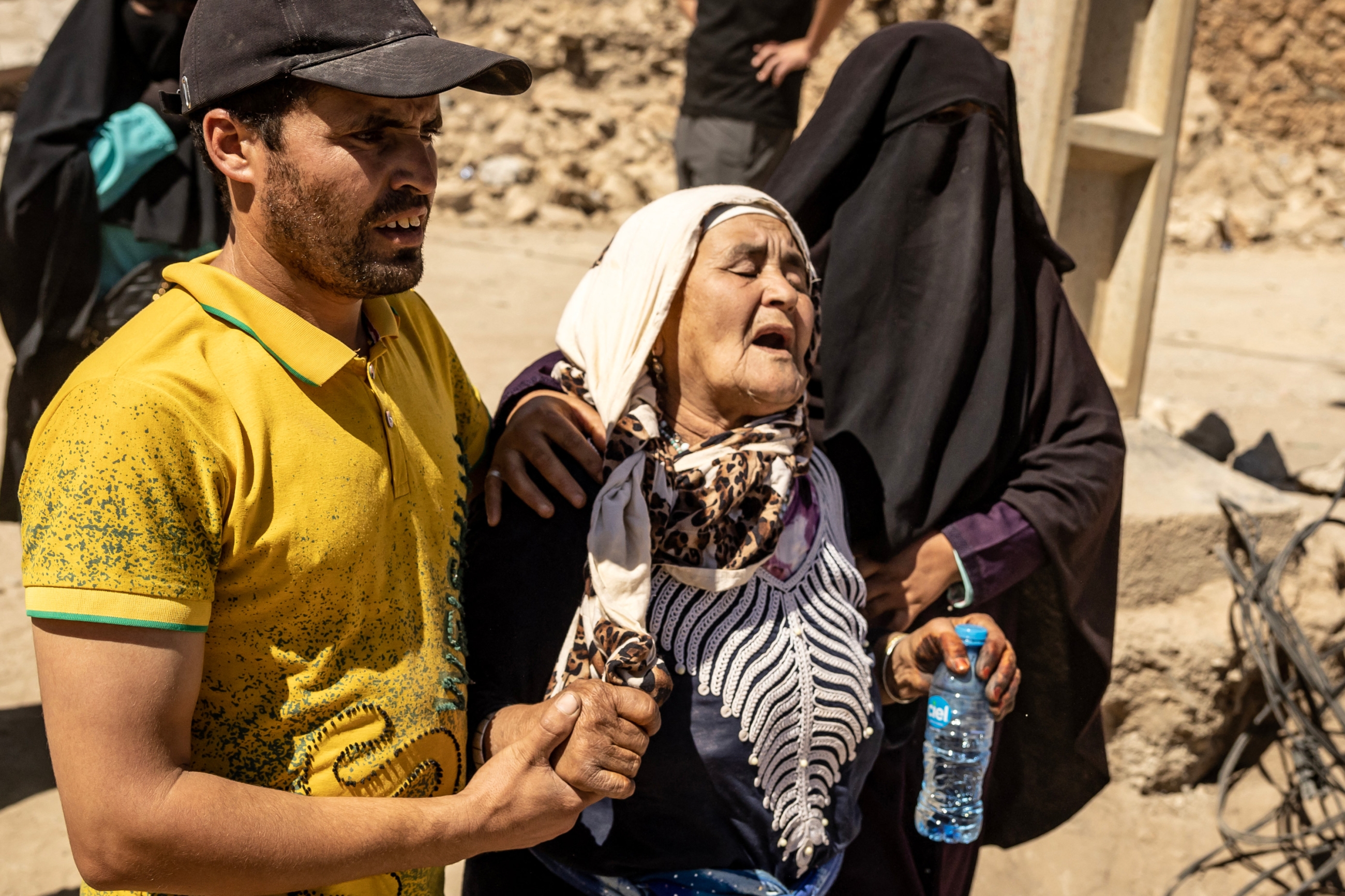 A woman is helped as she reacts to the death of relatives in an earthquake in the mountain village of Tafeghaghte, southwest of Marrakech, on 10 September 2023 (AFP)