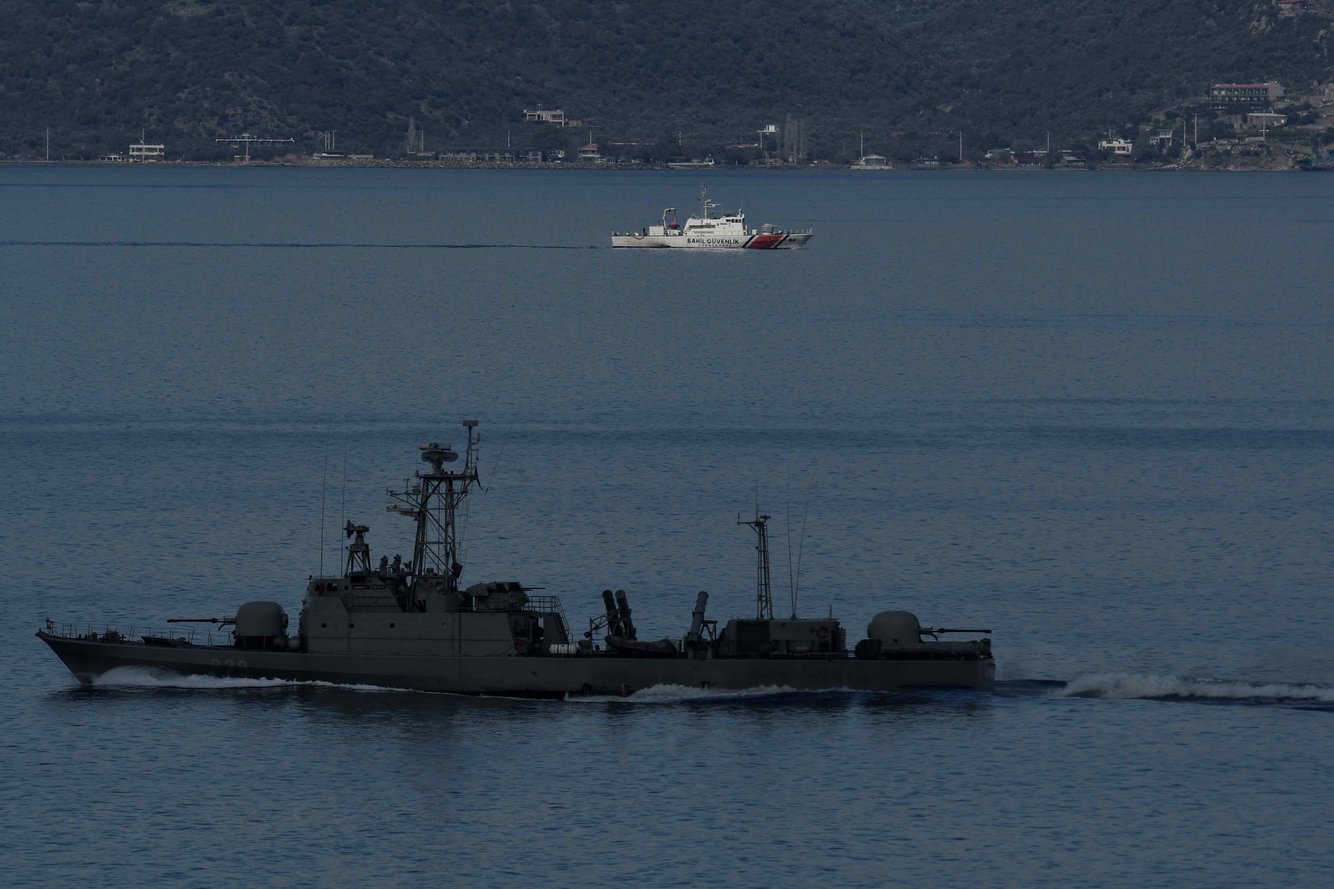 A Turkish military ship passes a coastgard patrol boat near the island of Lesbos (AFP)