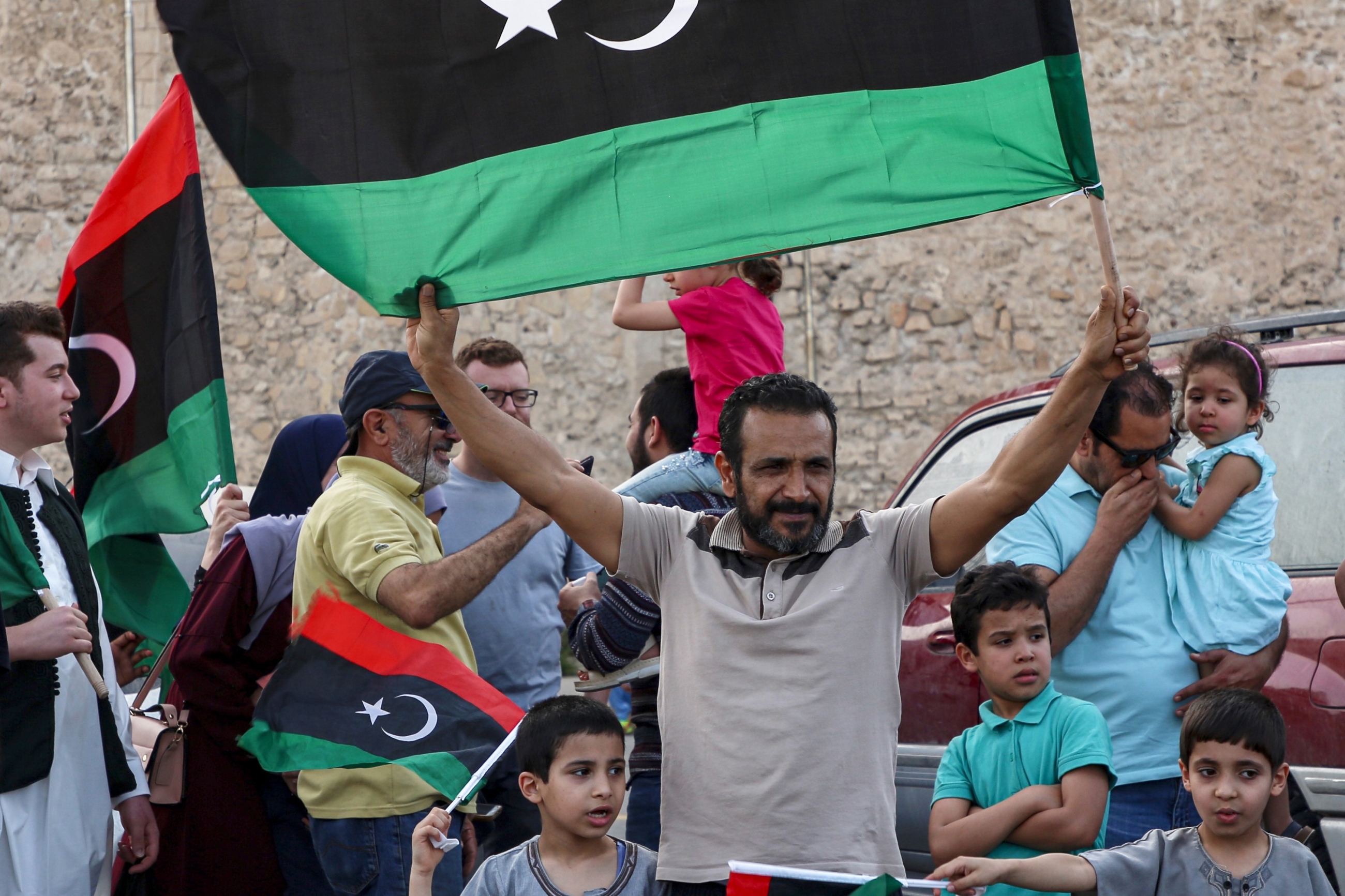 Un homme brandit un drapeau national libyen au cours de célébrations dans la capitale Tripoli, après que le Gouvernement d’union nationale (GNA) reconnu par l’ONU a déclaré avoir repris le contrôle total de la capitale le 4 juin (AFP)