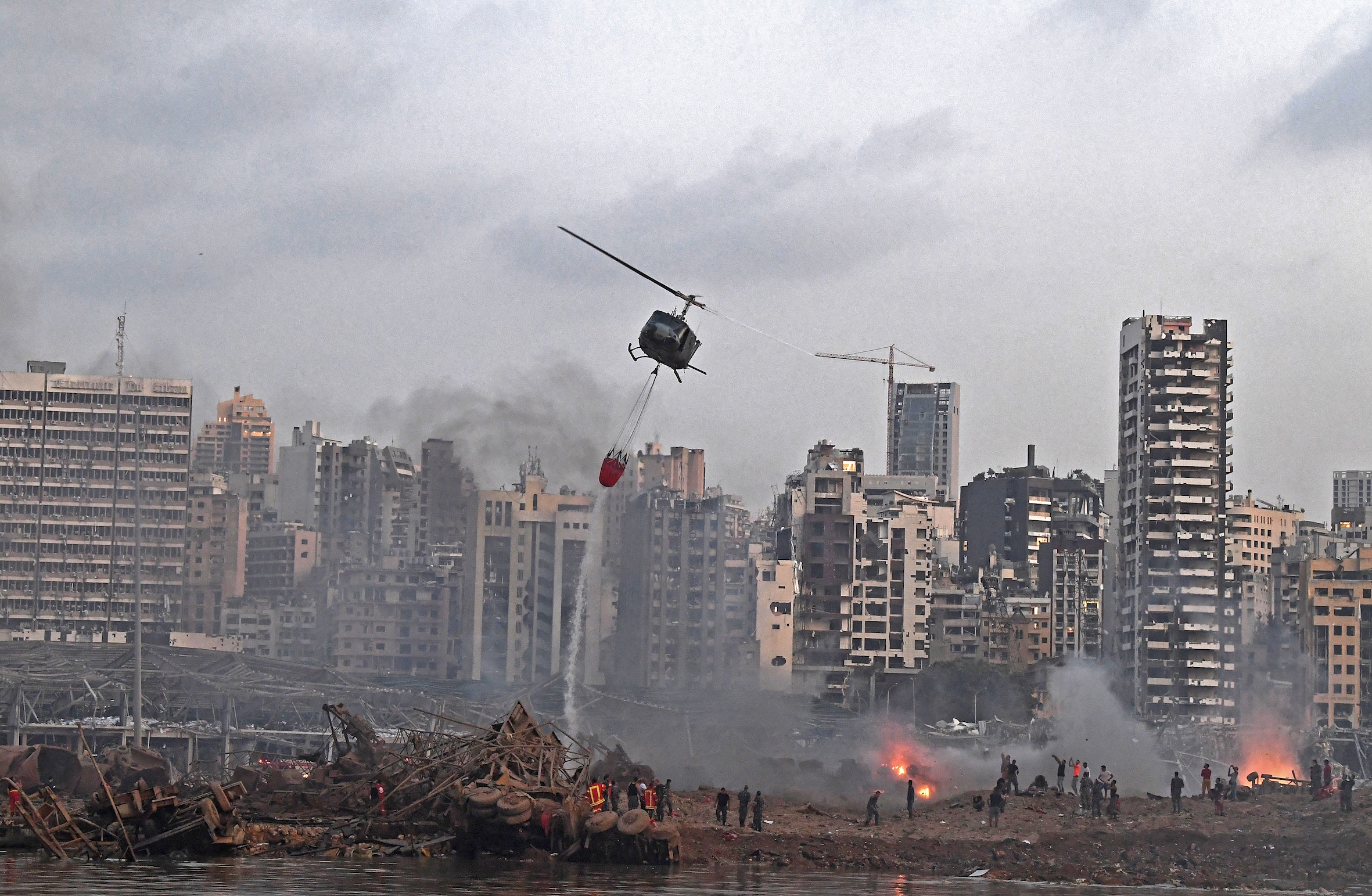 Un hélicoptère tente d’éteindre les multiples incendies provoqués par les explosions (AFP)