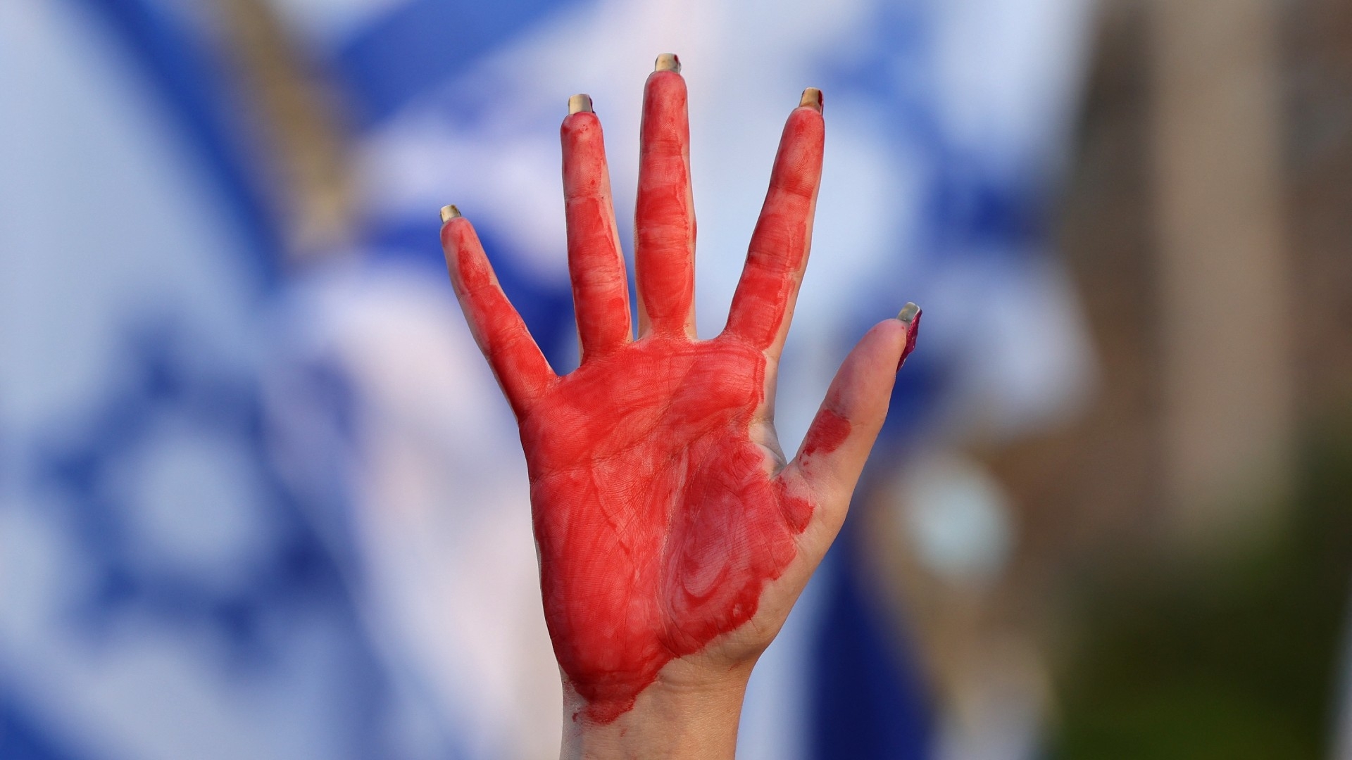 A demonstrator raises her hand, painted red, during a gathering to protest the Israeli government's judicial overhaul bill, in Tel Aviv on 6 May (AFP)