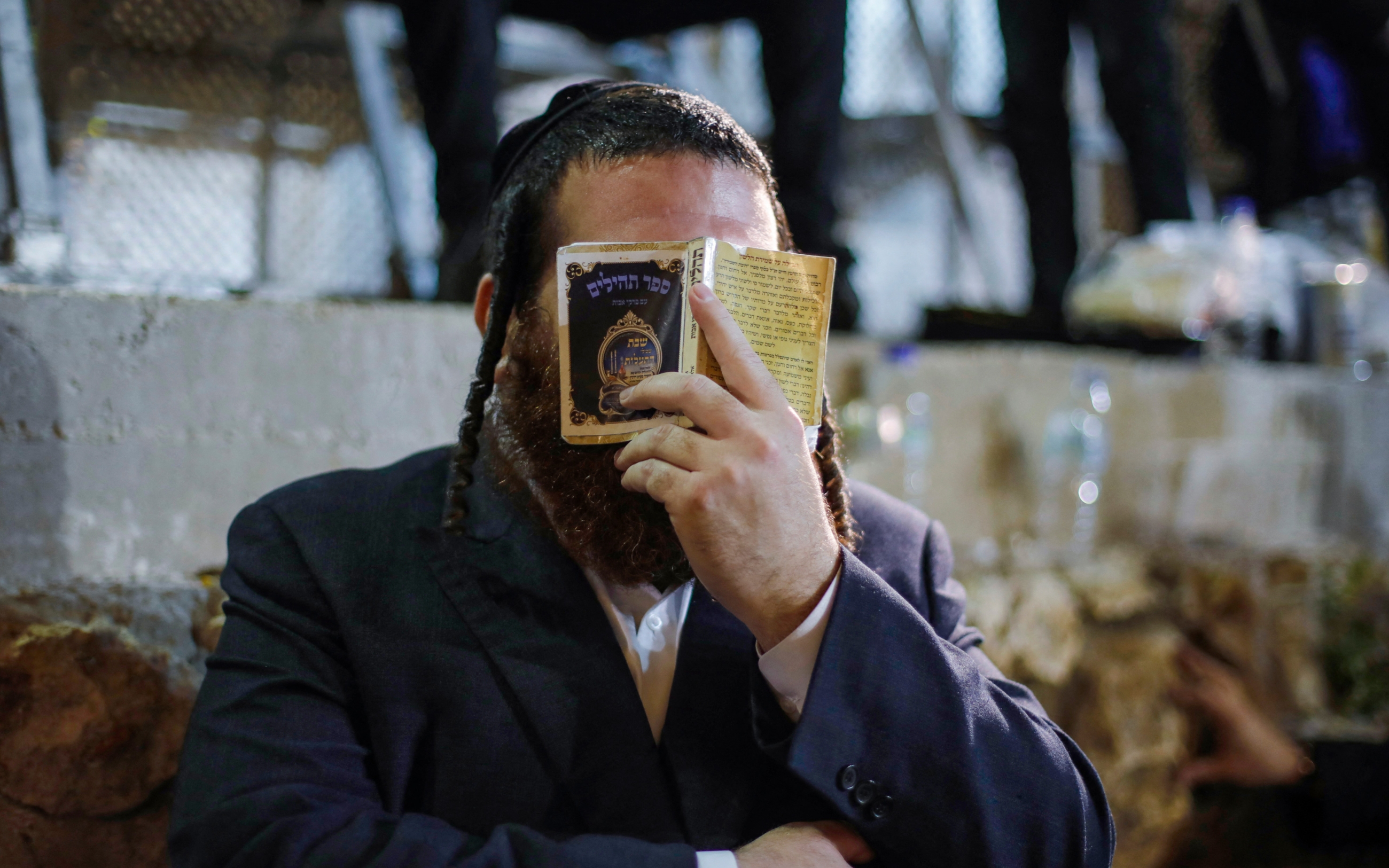 An ultra-Orthodox Jew prays at the gravesite of Rabbi Shimon Bar Yochai at Mount Meron in northern Israel on 9 May 2023 (AFP)