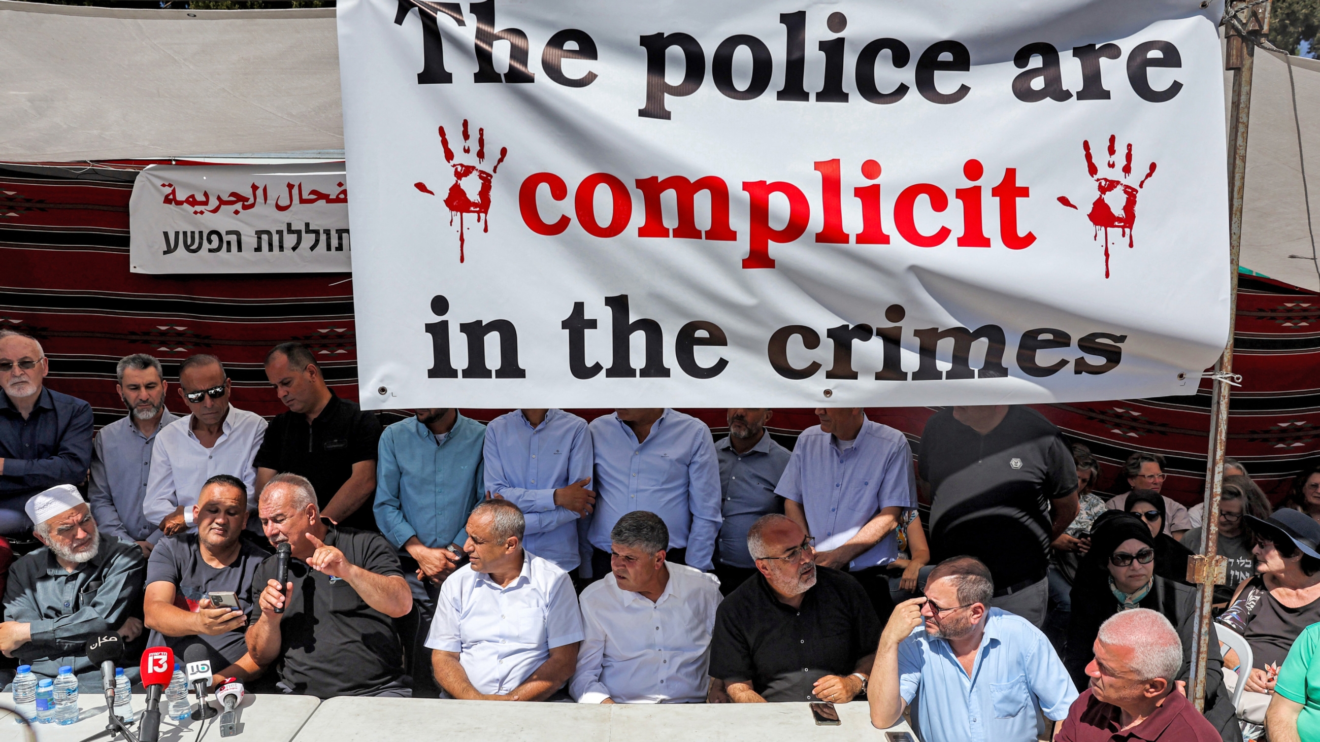 Mohammed Barakeh (3rd-L) speaks at a sit-in protesting gun violence among Palestinian citizens of Israel in Jerusalem on 31 May 2023 (AFP)
