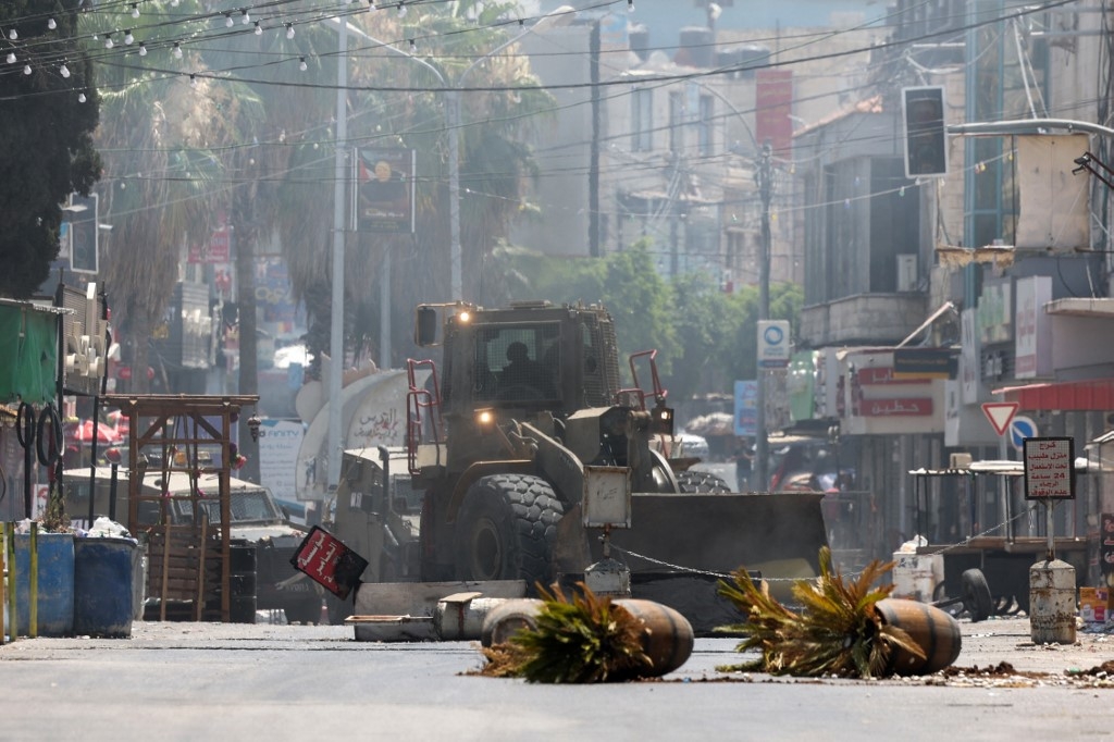 Un bulldozer de l’armée israélienne traverse Jénine en Cisjordanie occupée lors d’une opération militaire, le 3 juillet 2023 (AFP)
