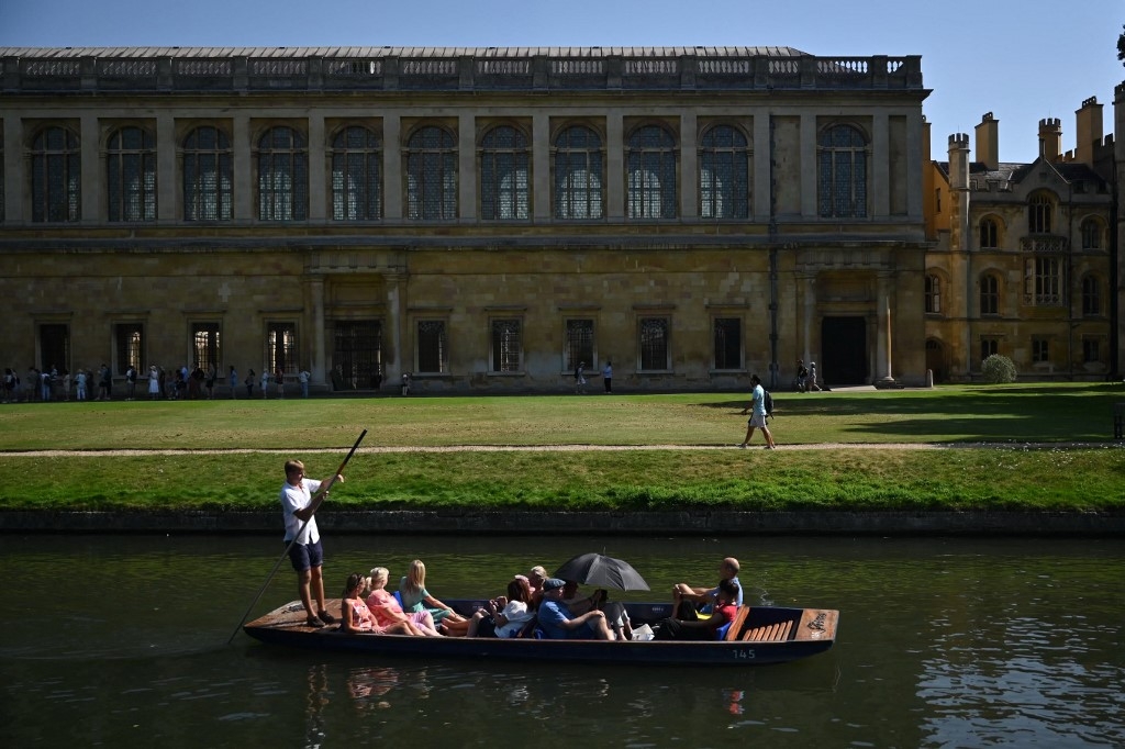 People punt past the Wren Library, part of Trinity College, on the River Cam in Cambridge, England, on 9 September 2023 (Justin Tallis/AFP)