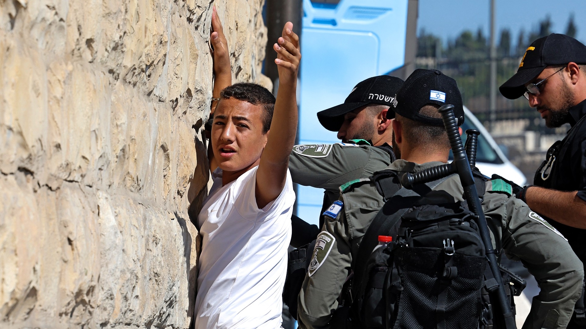 Israeli border guards search a Palestinian youth outside the Lion's Gate of the Old City of Jerusalem on 13 October (AFP)