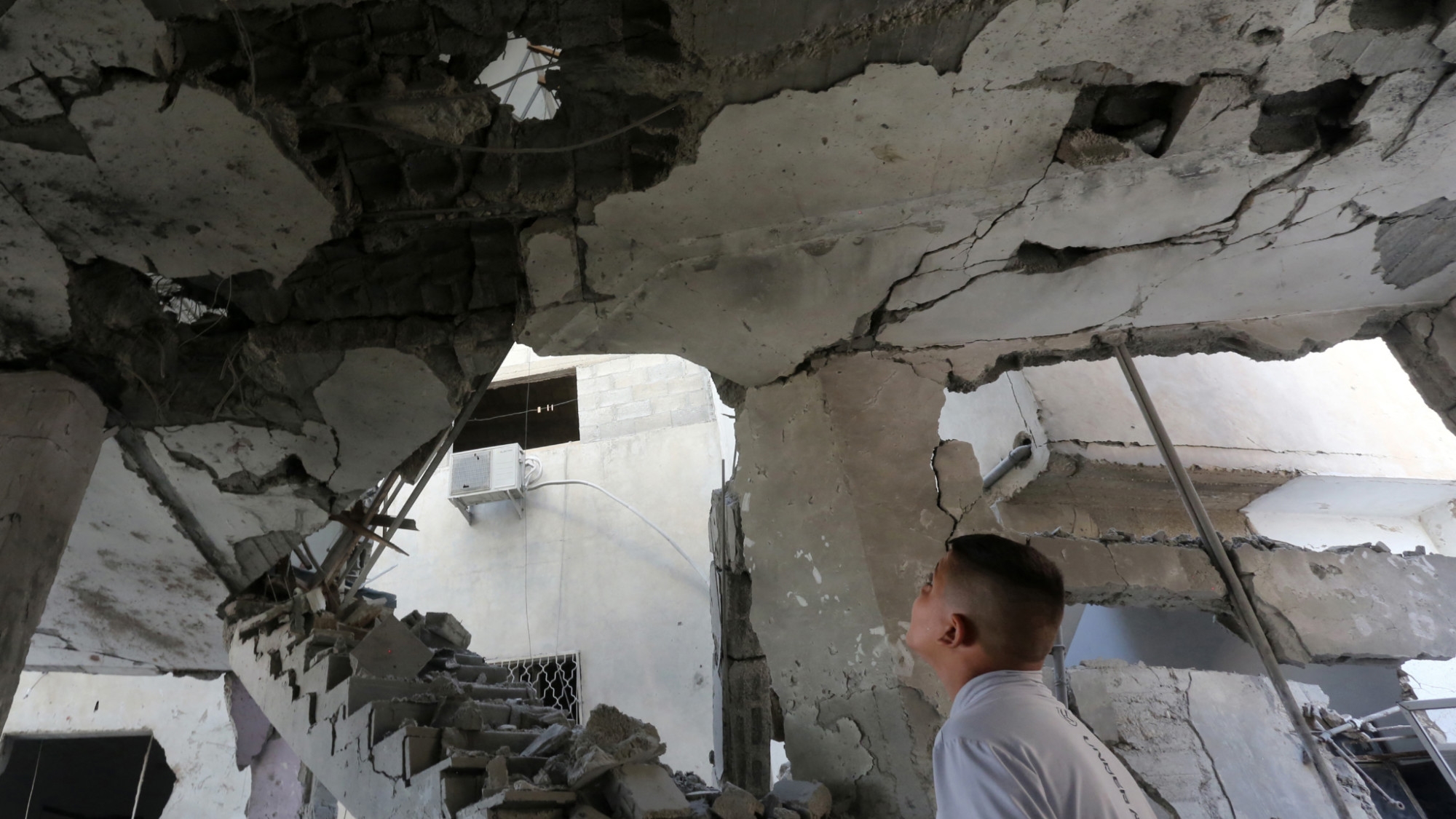 A man checks the damage inside a building in the occupied West Bank city of Jenin, following an Israeli air strike on 22 October 2023 (AFP)