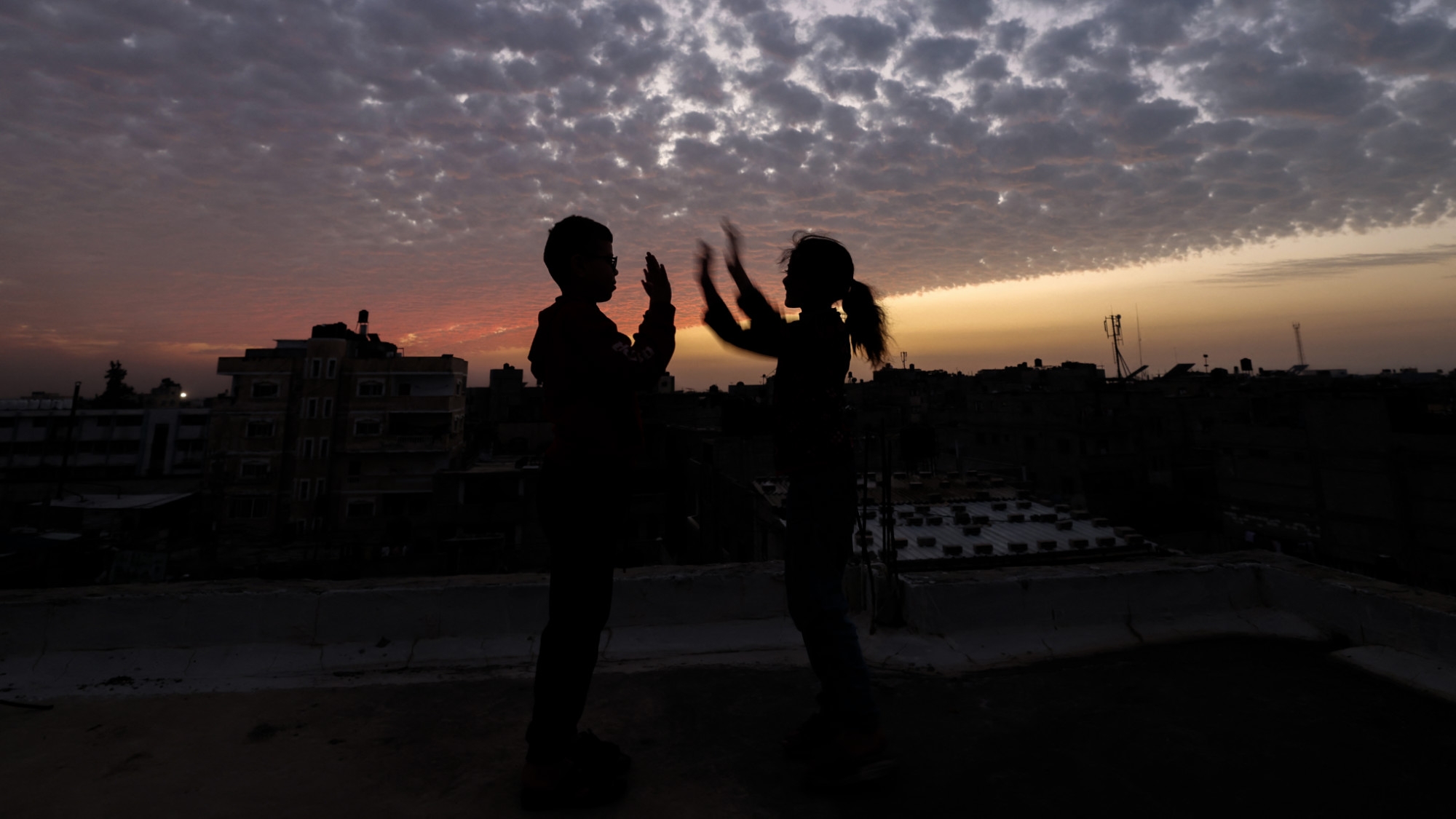 Des enfants jouent sur le toit d’un bâtiment à Rafah, dans le sud de la bande de Gaza, le 21 décembre 2023 (Mohammed Abed/AFP)
