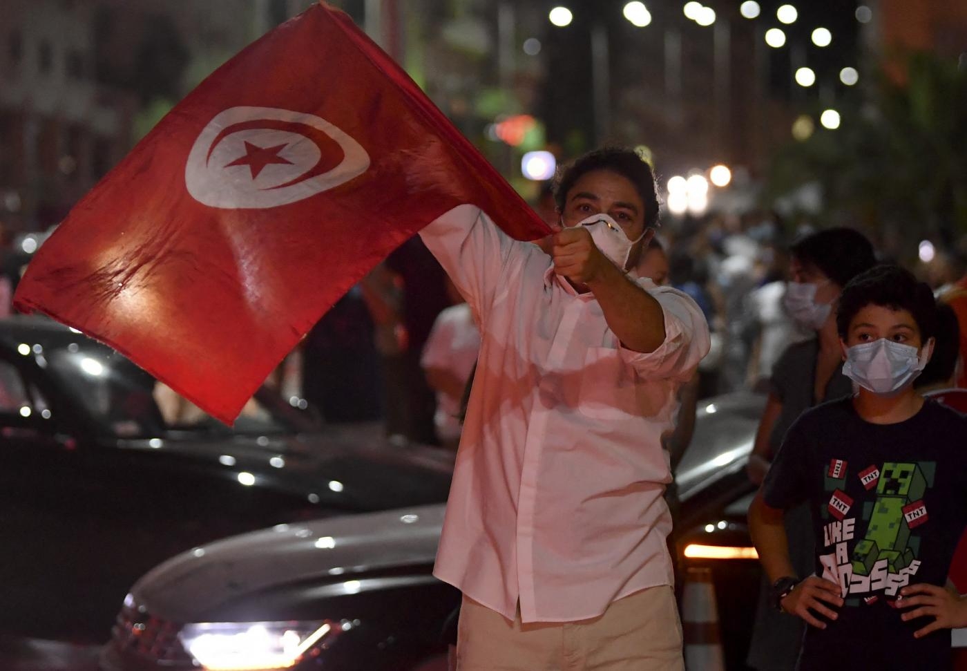 À Tunis le 25 juillet 2021, des gens célèbrent la décision du président Kais Saied de suspendre le Parlement et de limoger son chef du gouvernement après une journée de manifestations nationales (AFP)