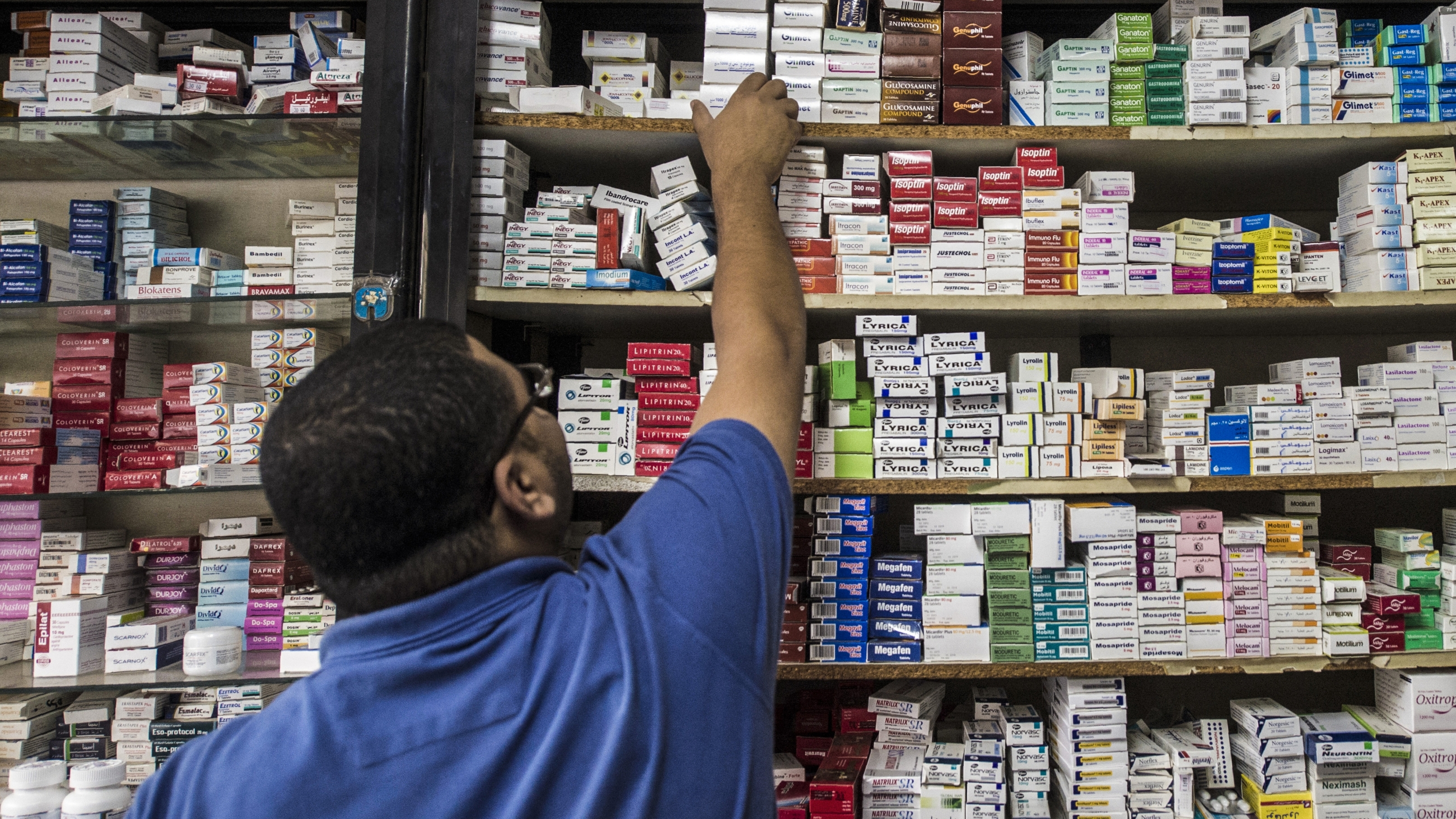 An Egyptian pharmacy employee reaches out to grab a box of medicine in a pharmacy in the capital Cairo on 9 November 2016 (AFP)