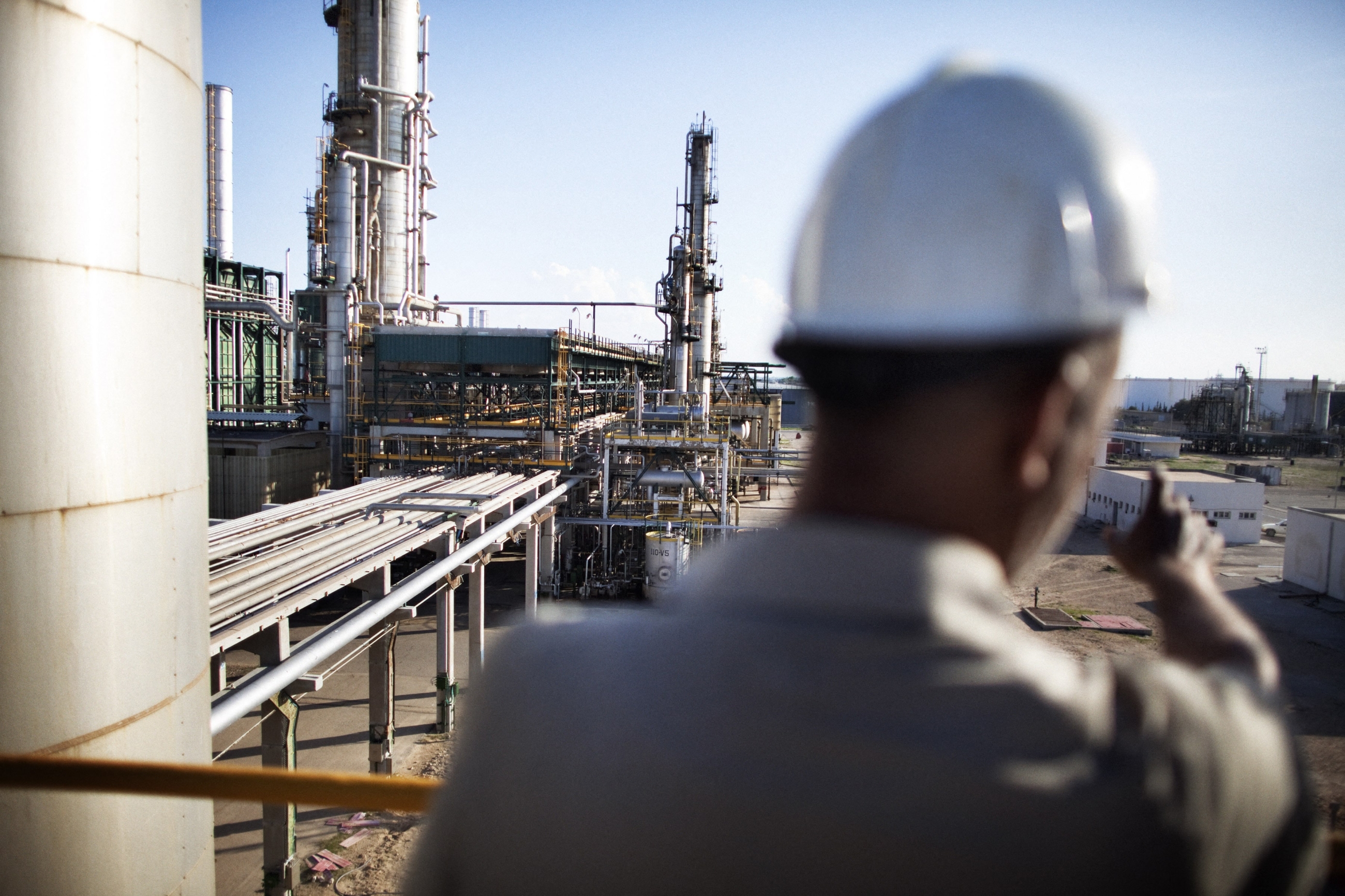Un ouvrier de la raffinerie de pétrole de Zaouïa, à une quarantaine de kilomètres à l’ouest de Tripoli, sur une plateforme surplombant l’installation, le 27 octobre 2011 (AFP) 