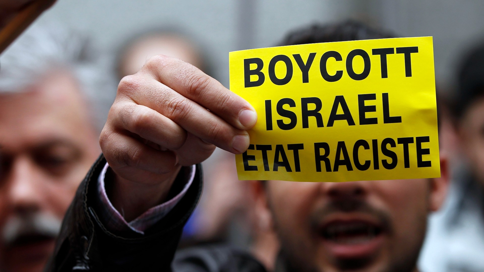 A demonstrator displays a sign reading "Boycott Israel, racist state" outside the Belgian foreign affairs building during a protest in Brussels in 2010 (Reuters)