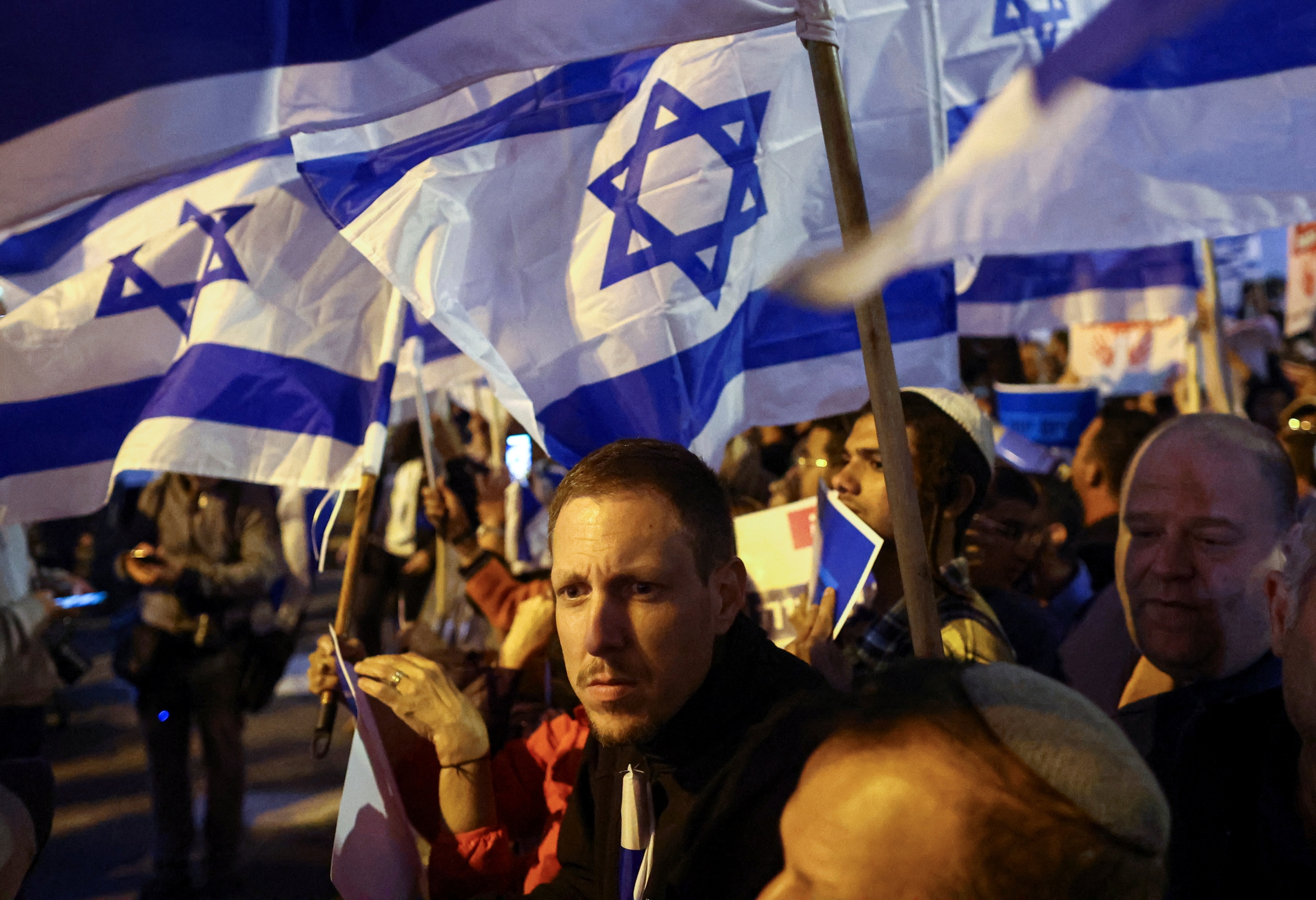 Israeli activists wave national flags during a right-wing rally in Jerusalem on 6 April 2022. (Reuters)