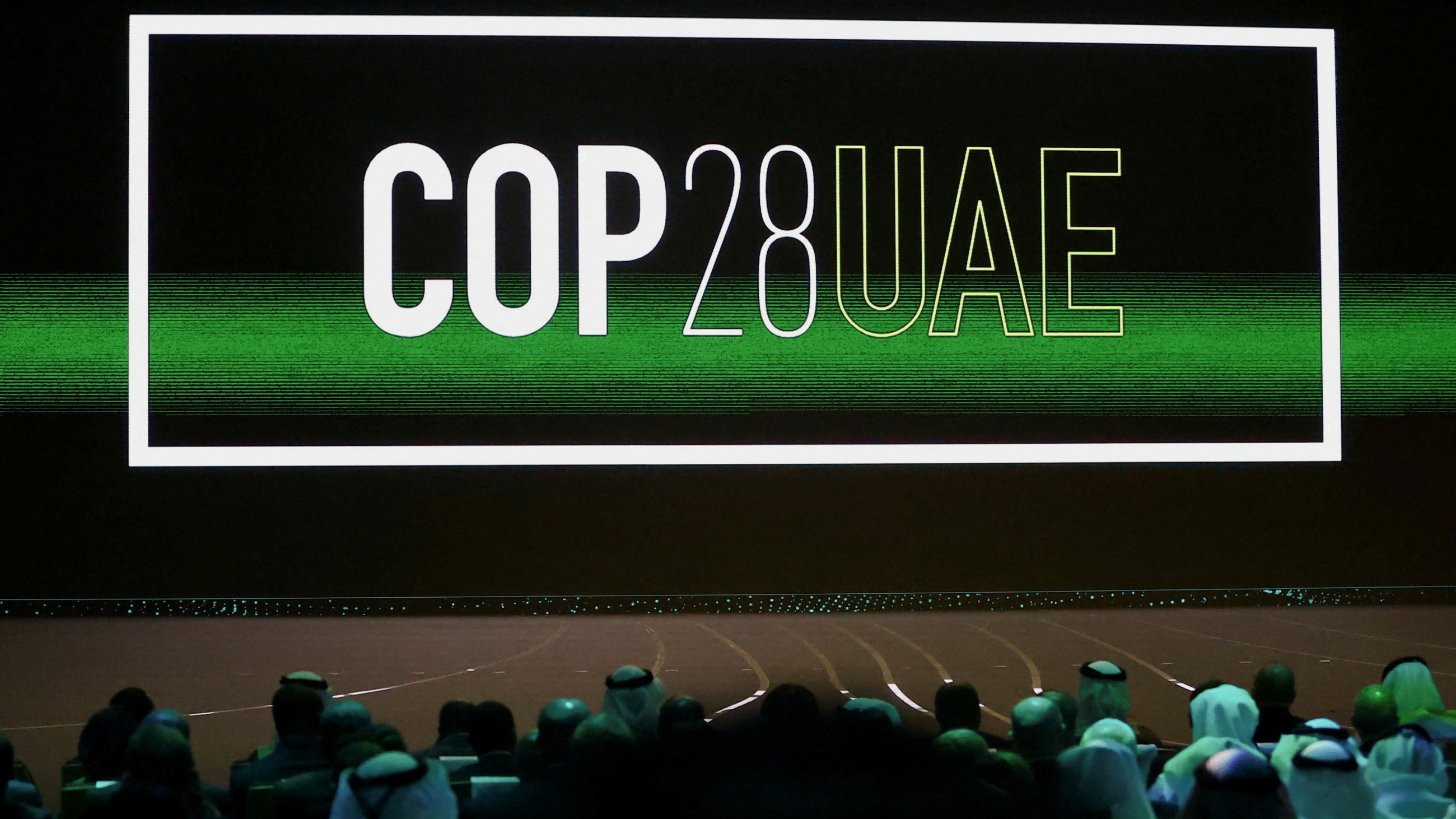 The Cop28 UAE logo is displayed on the screen during the opening ceremony of Abu Dhabi Sustainability Week (ADSW) in Abu Dhabi on 16 January 2023 (Reuters)