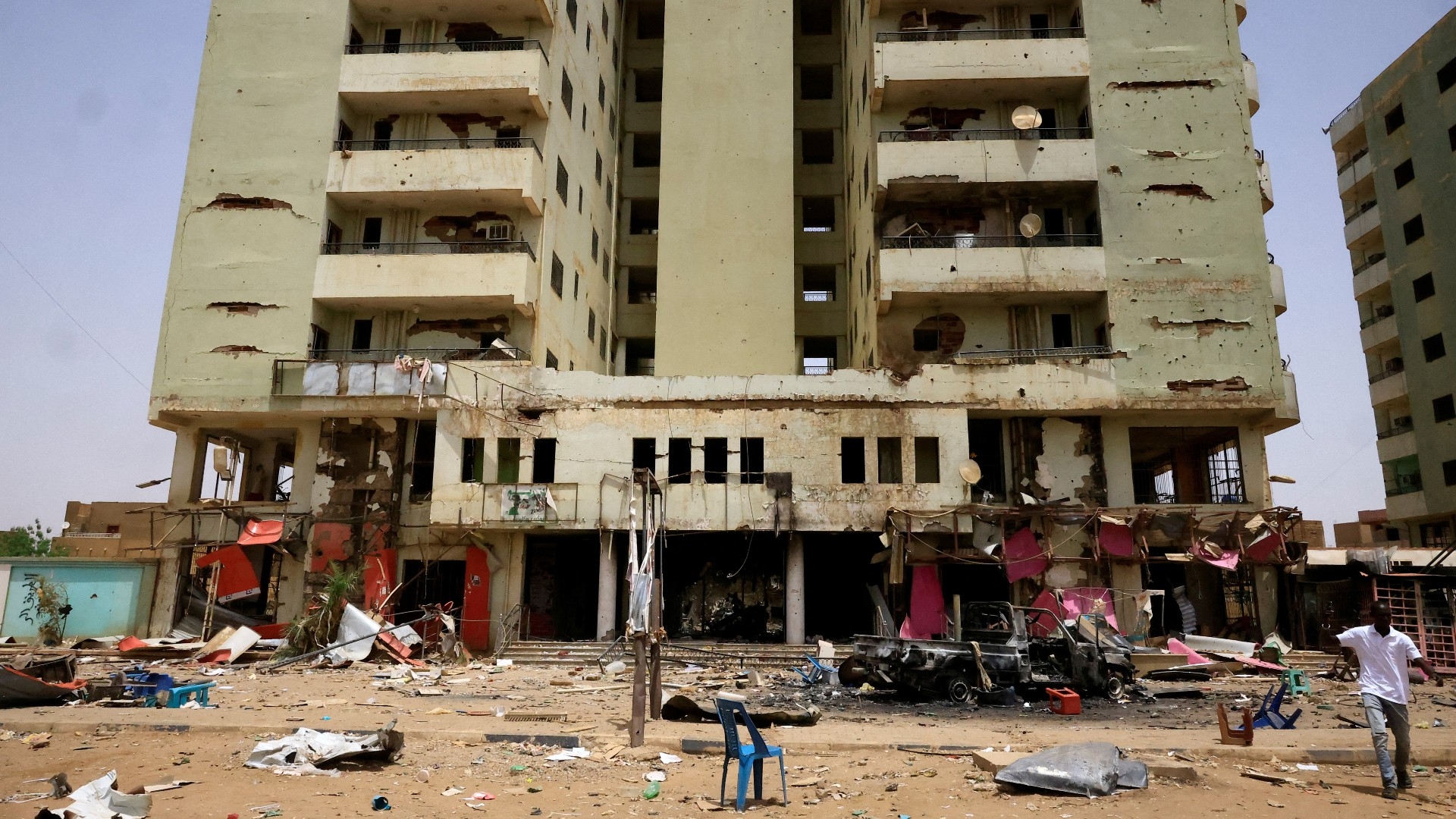 A man walks near the damaged central market during clashes between Rapid Support Forces and the army in Khartoum North, 27 April (Reuters)