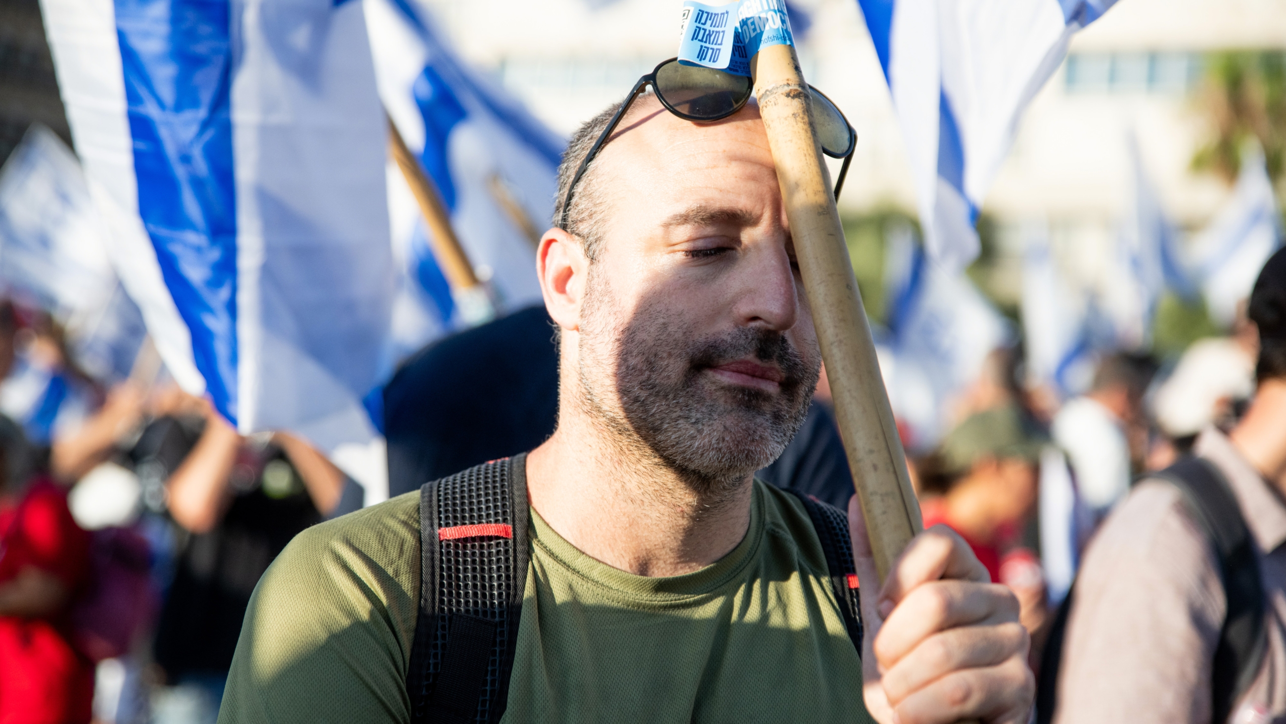Un réserviste israélien signataire d’une déclaration de « refus de se présenter au travail »  manifeste contre le projet de réforme crise judiciaire, devant le quartier général de l’armée, à Tel Aviv, le 19 juillet 2023 (Reuters)