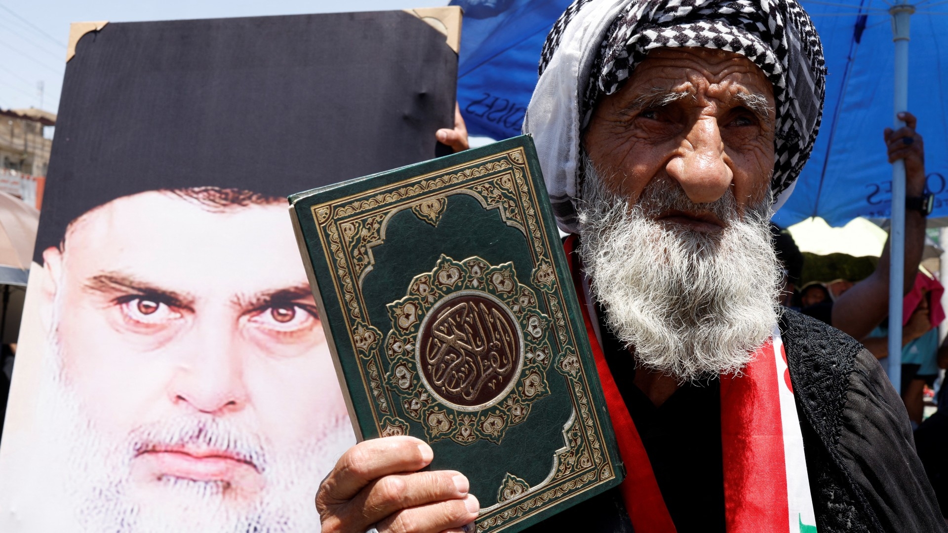 A man holds Quran as supporters of Muqtada al-Sadr take part in a protest ahead of an expected Quran burning in Stockholm, in Baghdad, on 21 July (Reuters)