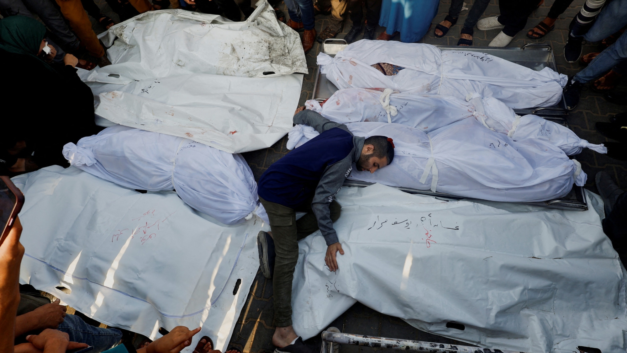 A mourner reacts amidst the bodies as people attend a funeral of Palestinians killed in Israeli strikes in Khan Younis, southern Gaza Strip, 24 October 2023 (Reuters)