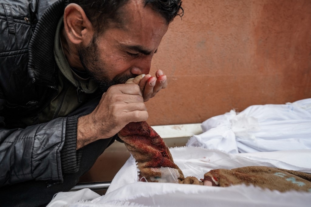 Un Palestinien pleure sur la dépouille d’un enfant tué par une frappe israélienne sur l’hôpital al-Nasser à Khan Younès, dans le sud de la bande de Gaza, le 28 décembre 2023 (AFP)