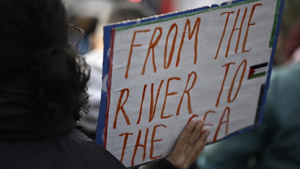 A demonstrator displays a sign saying 'From the river to the sea' during a rally in solidarity with Palestinians in Berlin on 11 November 2023 (AFP)