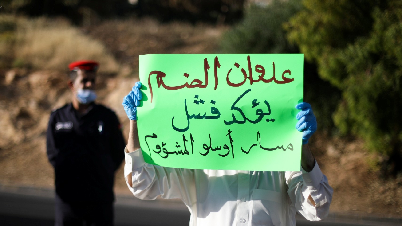 A protester holds a placard as he takes part in a demonstration against the annexation of parts of the West Bank by Israel, in Amman, Jordan, in June 2020