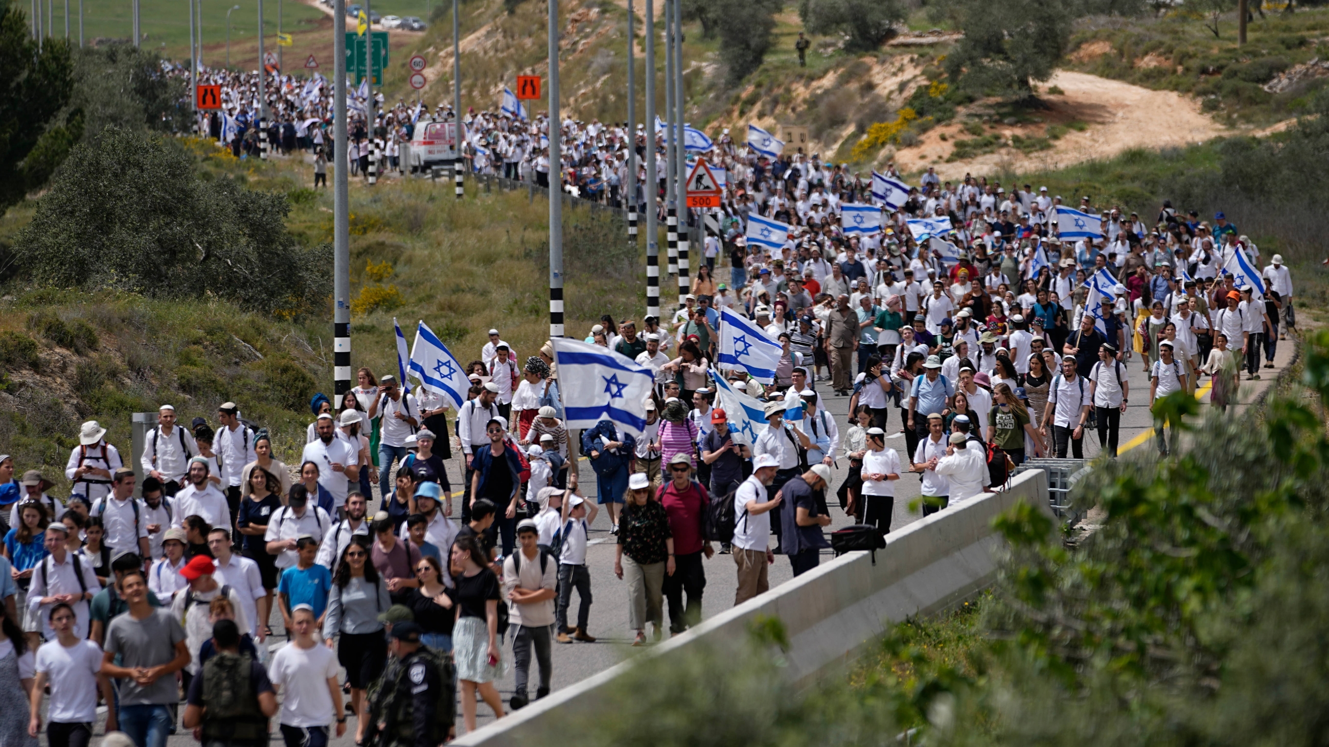 Israeli settlers march to Evyatar outpost near Nablus in the occupied West Bank on 10 April 2023 (AP)