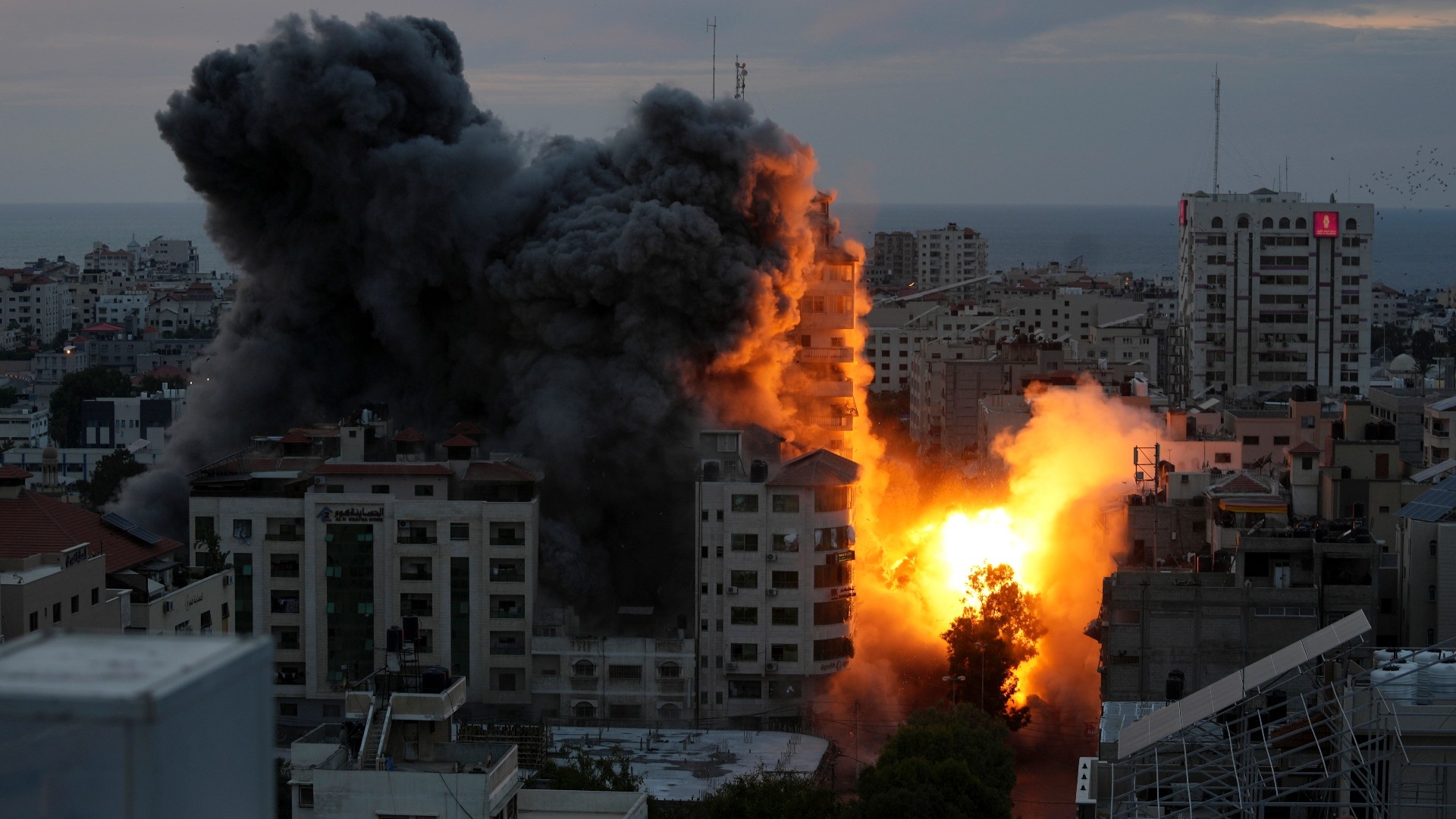 A ball of fire and smoke rise from an explosion on a Palestinian apartment tower following an Israeli air strike in Gaza City (AP)