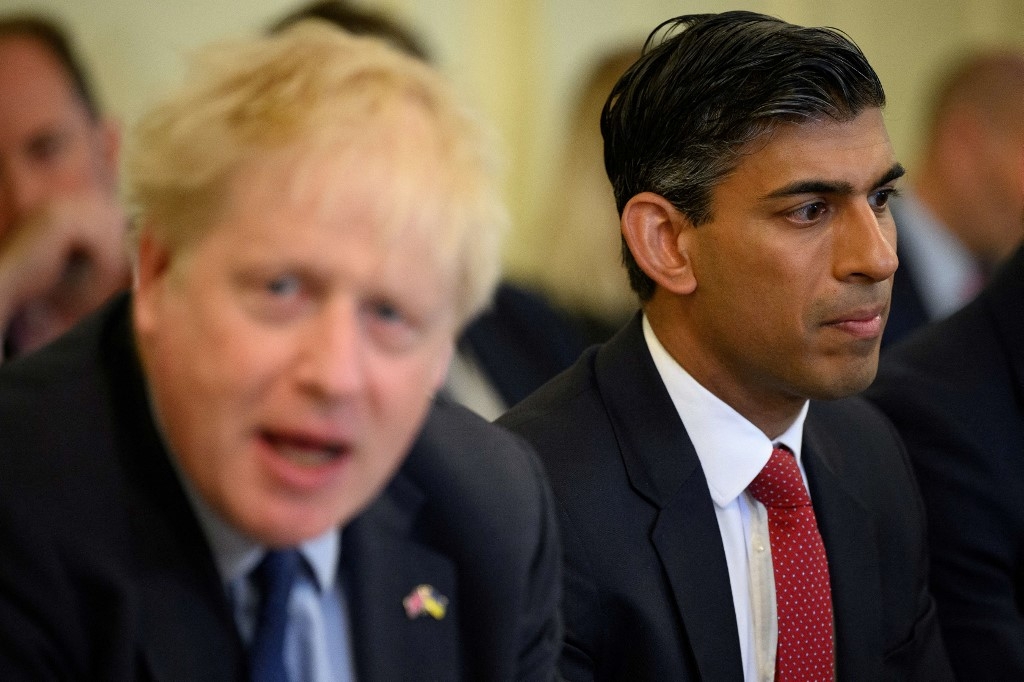 Britain's Chancellor of the Exchequer Rishi Sunak (R) reacts as Britain's Prime Minister Boris Johnson speaks during a Cabinet meeting at 10 Downing Street, in London, on June 7, 2022