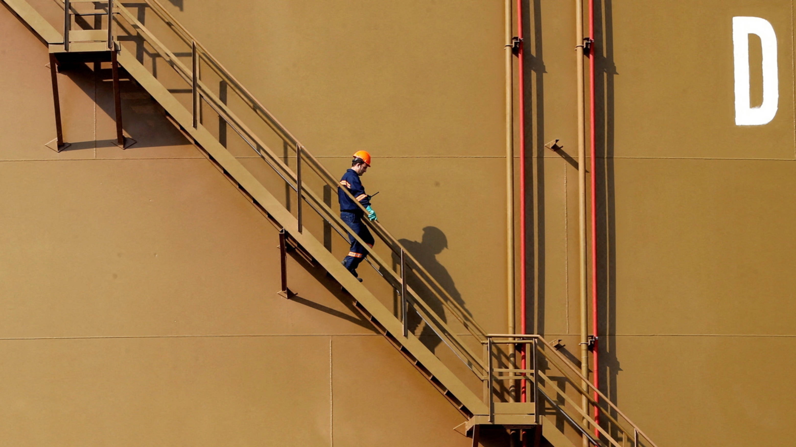 A worker walks down the stairs of an oil tank at Turkey's Mediterranean port of Ceyhan 19 February 2014 (Reuters/file)