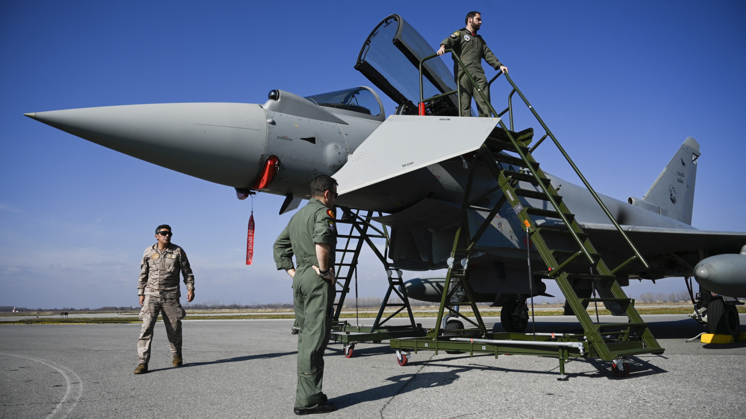 Spanish pilots stand next to a Spanish Eurofighter EF-2000 Typhoon II aircraft at Graf Ignatievo airbase on 17 February 2022 (AFP)