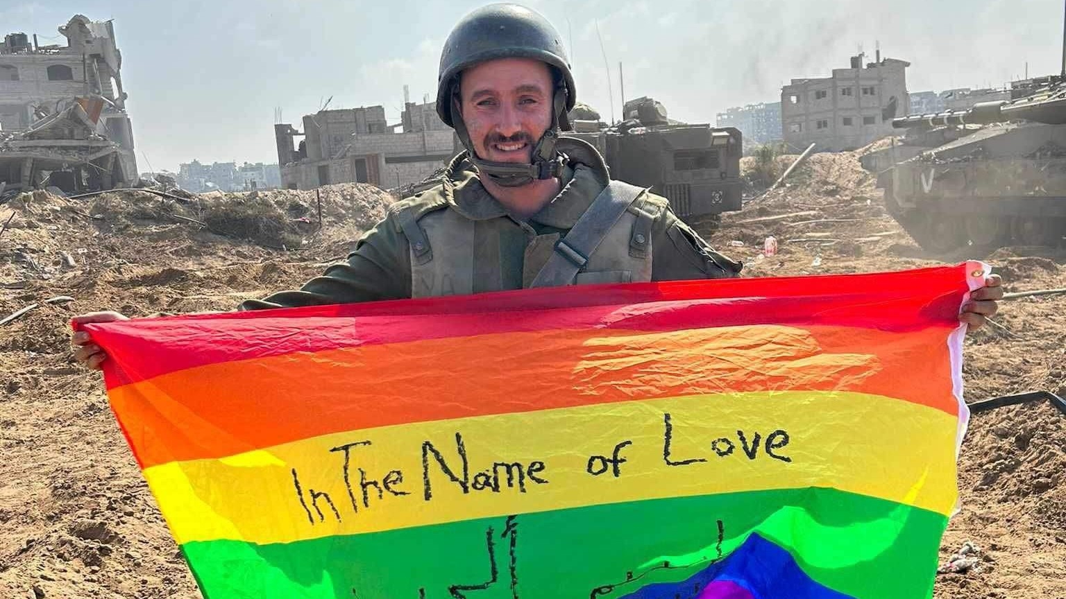 Yoav Atzmoni holds a rainbow flag in northern Gaza's al-Atatra (social media)