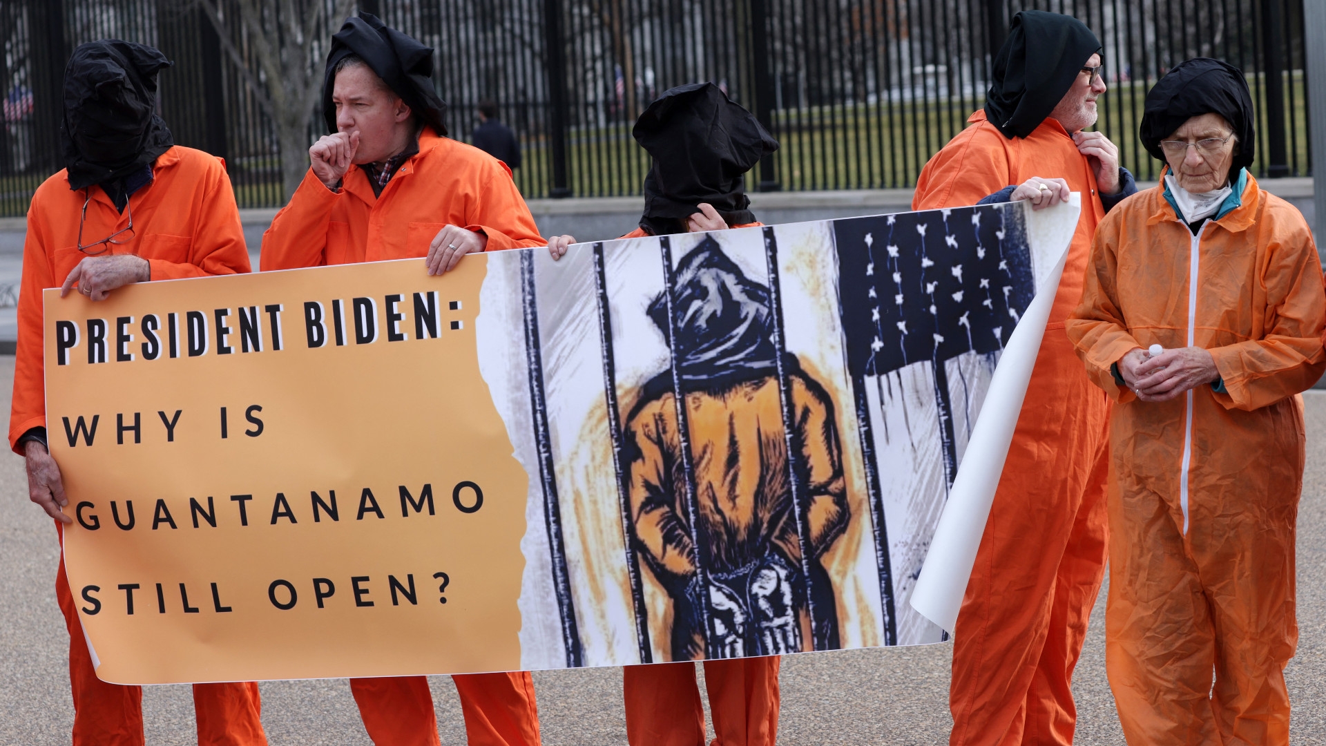Des activistes en tenue orange de prisonnier, représentant les détenus restant à Guantánamo, participent à une manifestation devant la Maison-Blanche, à Washington DC., le 11 janvier 2023 (AFP)
