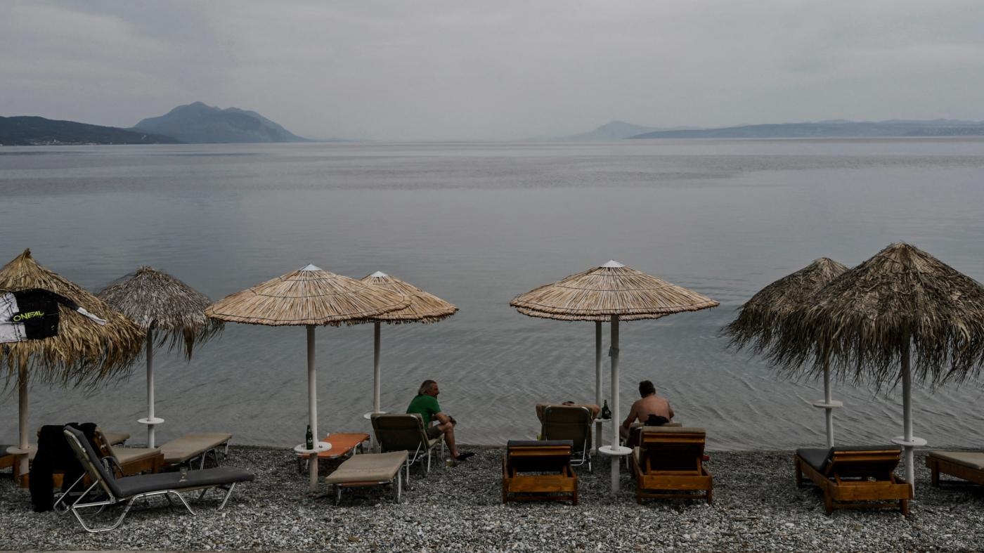 Des touristes fréquentent un café en bord de mer sur l’île grecque d’Eubée, le 5 mai 2021 (AFP)