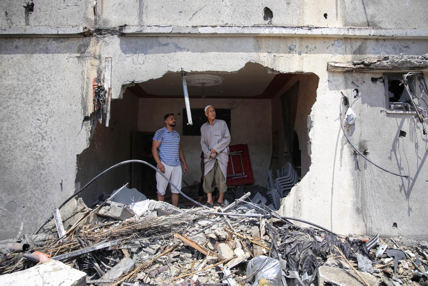 Des Palestiniens inspectent les restes d’une maison détruite par les frappes aériennes israéliennes sur la bande de Gaza, le 6 août 2022 (MEE/Mohammed al-Hajjar)