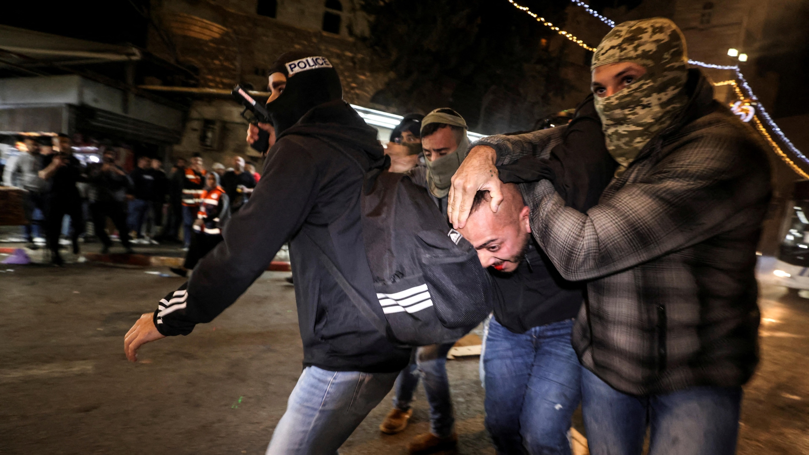 Israeli undercover police force detain a Palestinian at Damascus Gate by the entrance to Jerusalem's Old City on 3 April 2022. (AFP)
