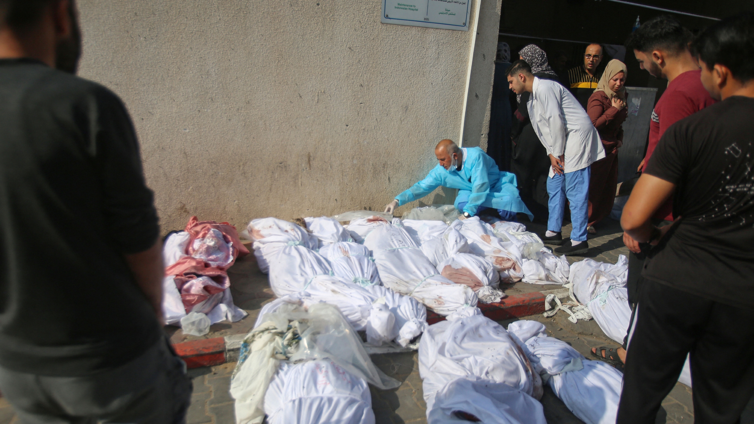 Palestinians check the bodies of victims laid out outside a hospital morgue in Gaza City a day after an Israeli strike on the Jabalia refugee camp on 1 November 2023 (Bashar Taleb/AFP)