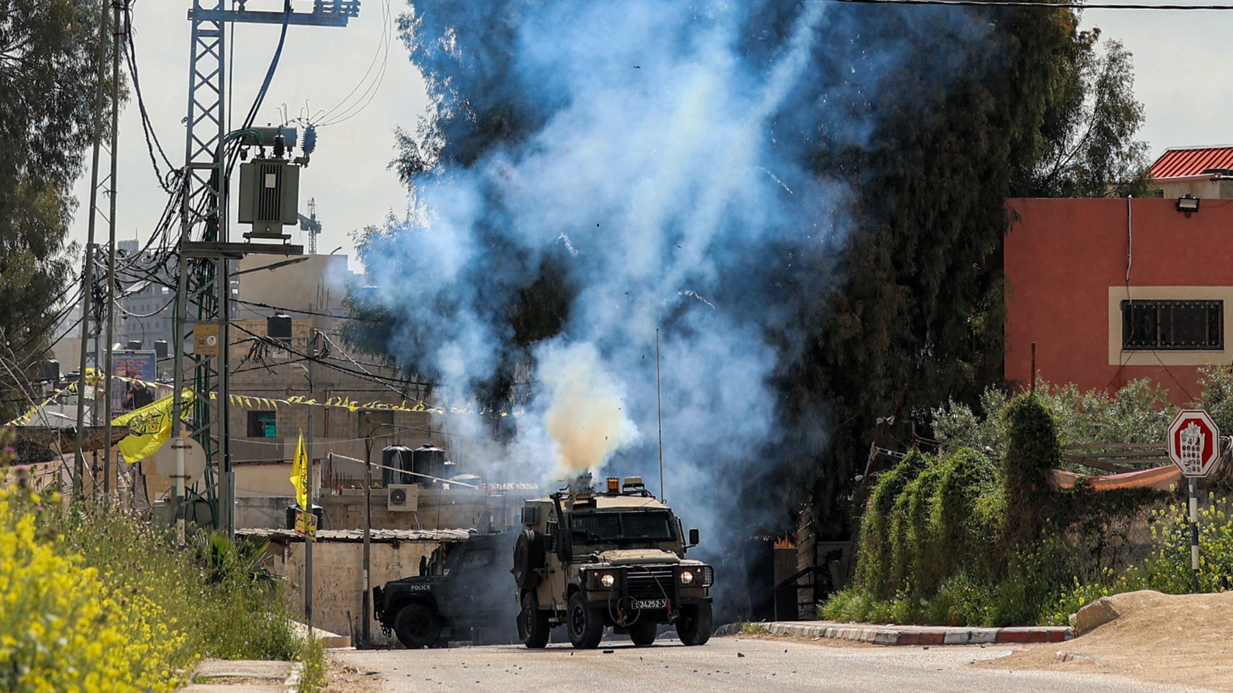 Tear gas canisters are fired from an Israeli military vehicle near the Palestinian refugee camp of Jenin in the occupied West Bank on 9 April 2022 (AFP)