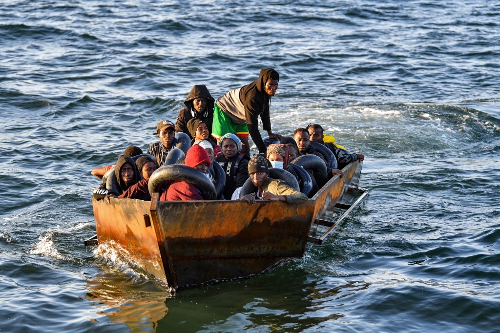 Migrants in a makeshift boat after being found heading for Italy by Tunisian authorities about 50 miles off the coast of Tunisia's city of Sfax on 4 October 2022 (AFP)