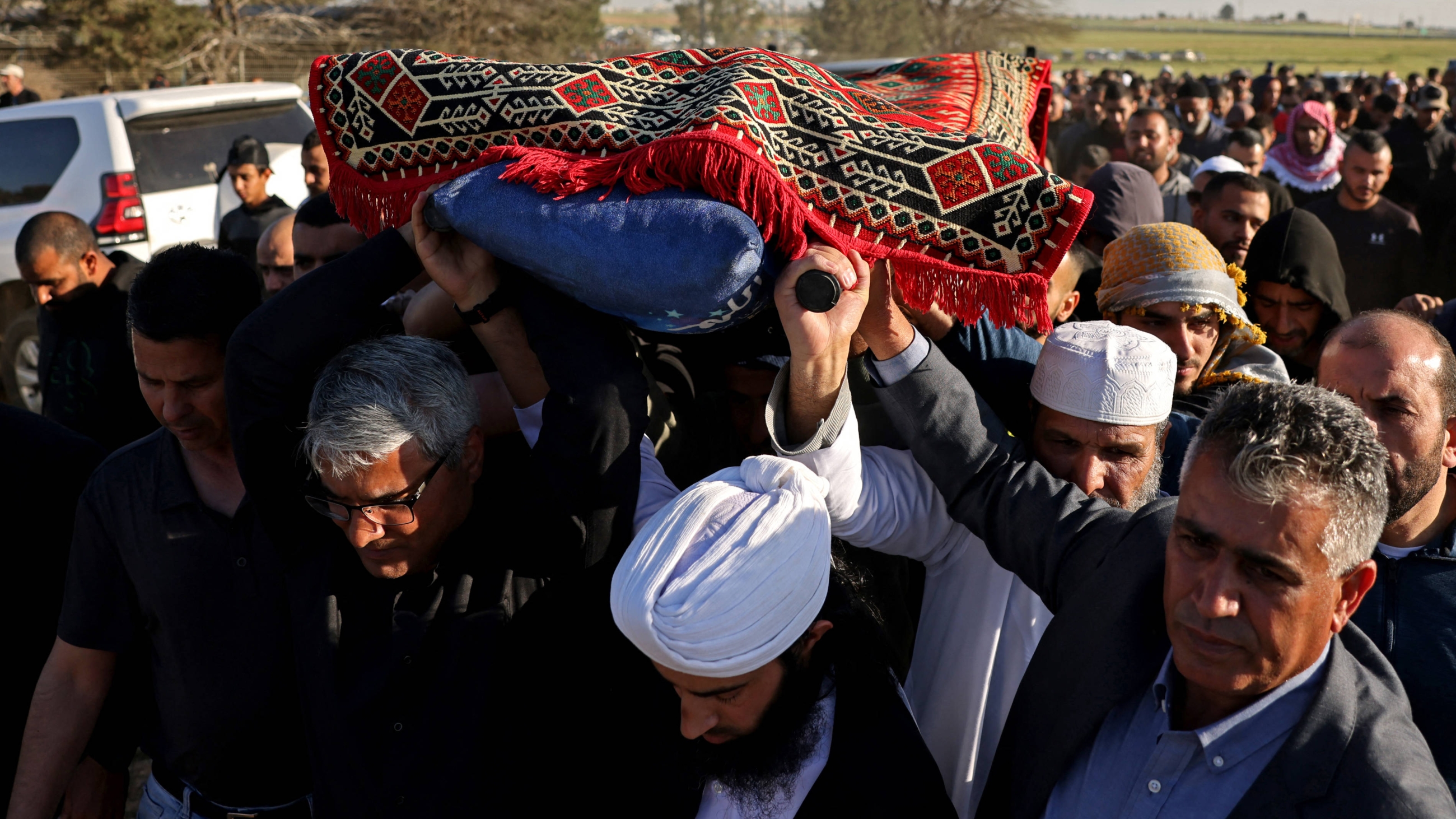 Mourners carry the body of Palestinian Mohammed al-Osaibi, during his funeral in the Bedouin village of Hura in southern Israel on 2 April 2023 (AFP)