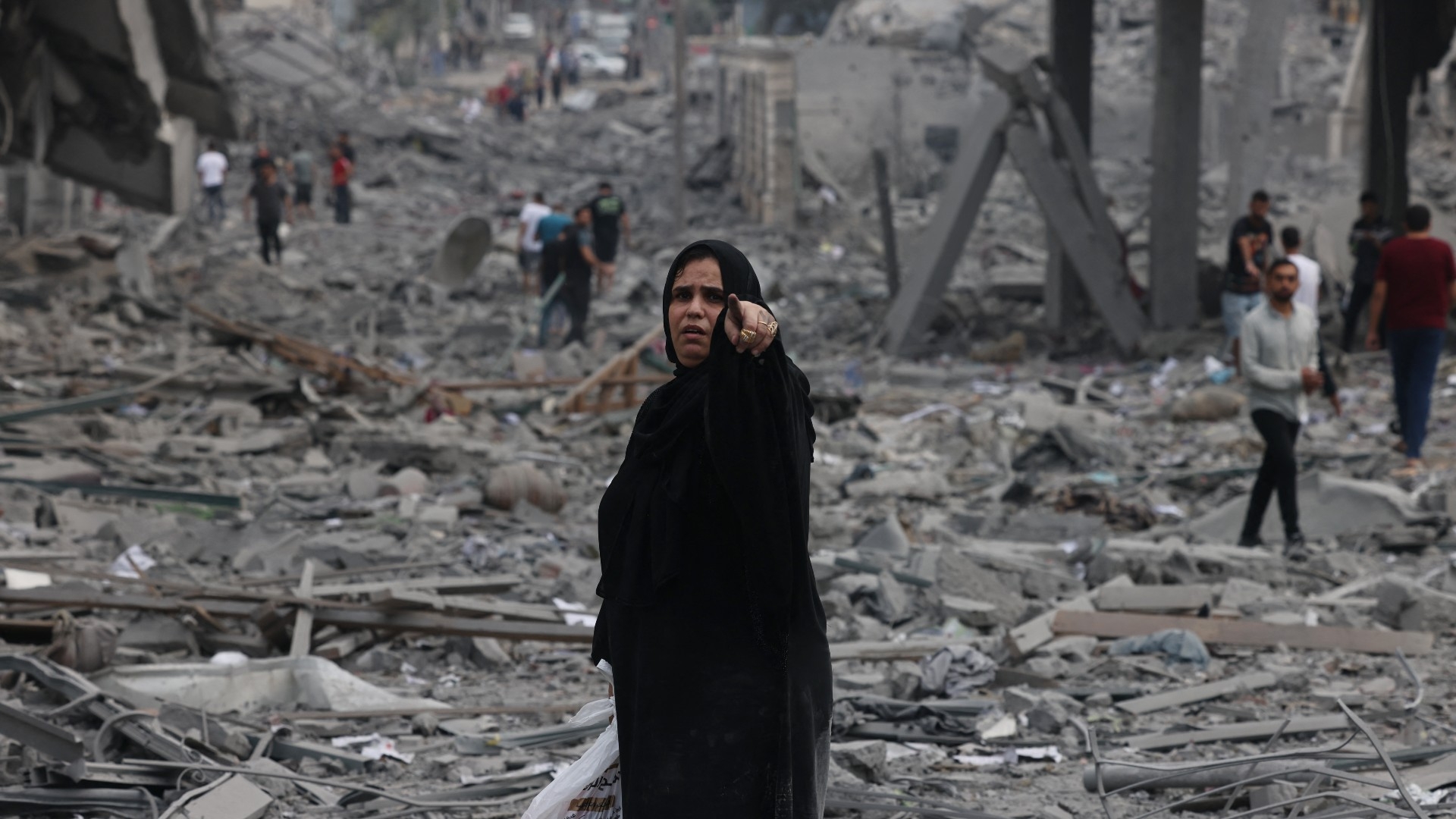 Des Palestiniens marchent parmi les décombres à la suite de frappes aériennes israéliennes dans le quartier d’al-Rimal à Gaza, le 10 octobre 2023 (AFP)