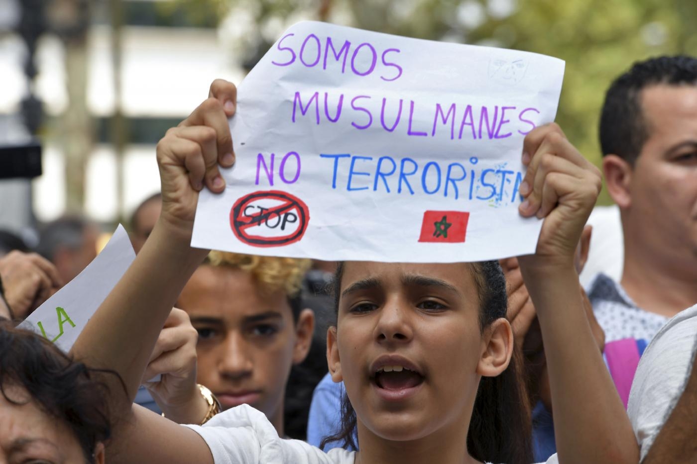 A girl holds a message reading 'We are Muslims, not terrorists' at a protest in Barcelona, 19 August 2017 (AFP)