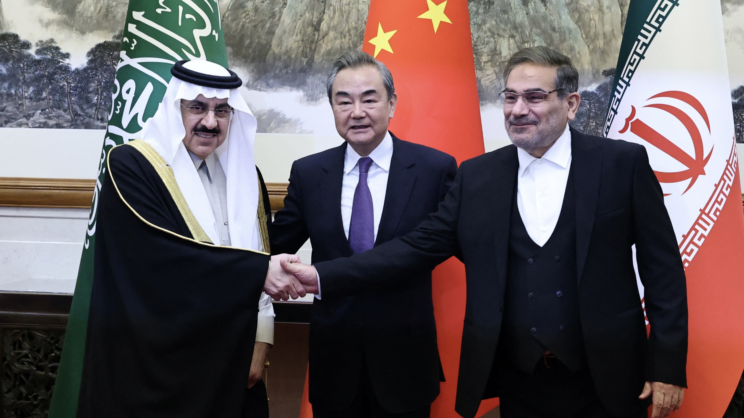 Wang Yi, of the Communist Party of China (C), Ali Shamkhani, of Iran’s Supreme National Security Council (R), and Saudi Arabia's national security adviser Musaad bin Mohammed al Aiban (L) during a meeting in Beijing, China, 10 March 2023 (Reuters)