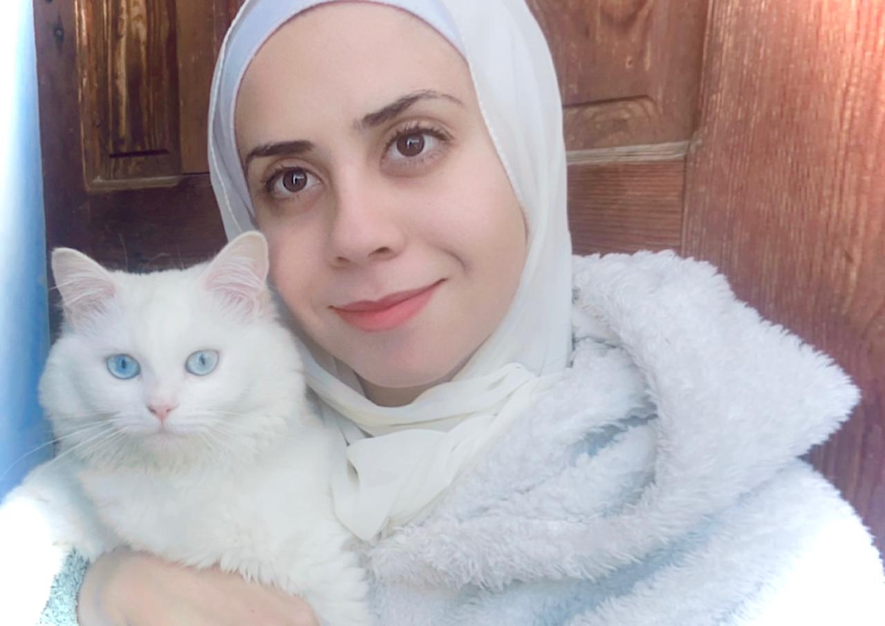 The author poses for a selfie with her cat Beasty as they seek shelter at a relative's home in April 2024 (Tarneem Hammad)