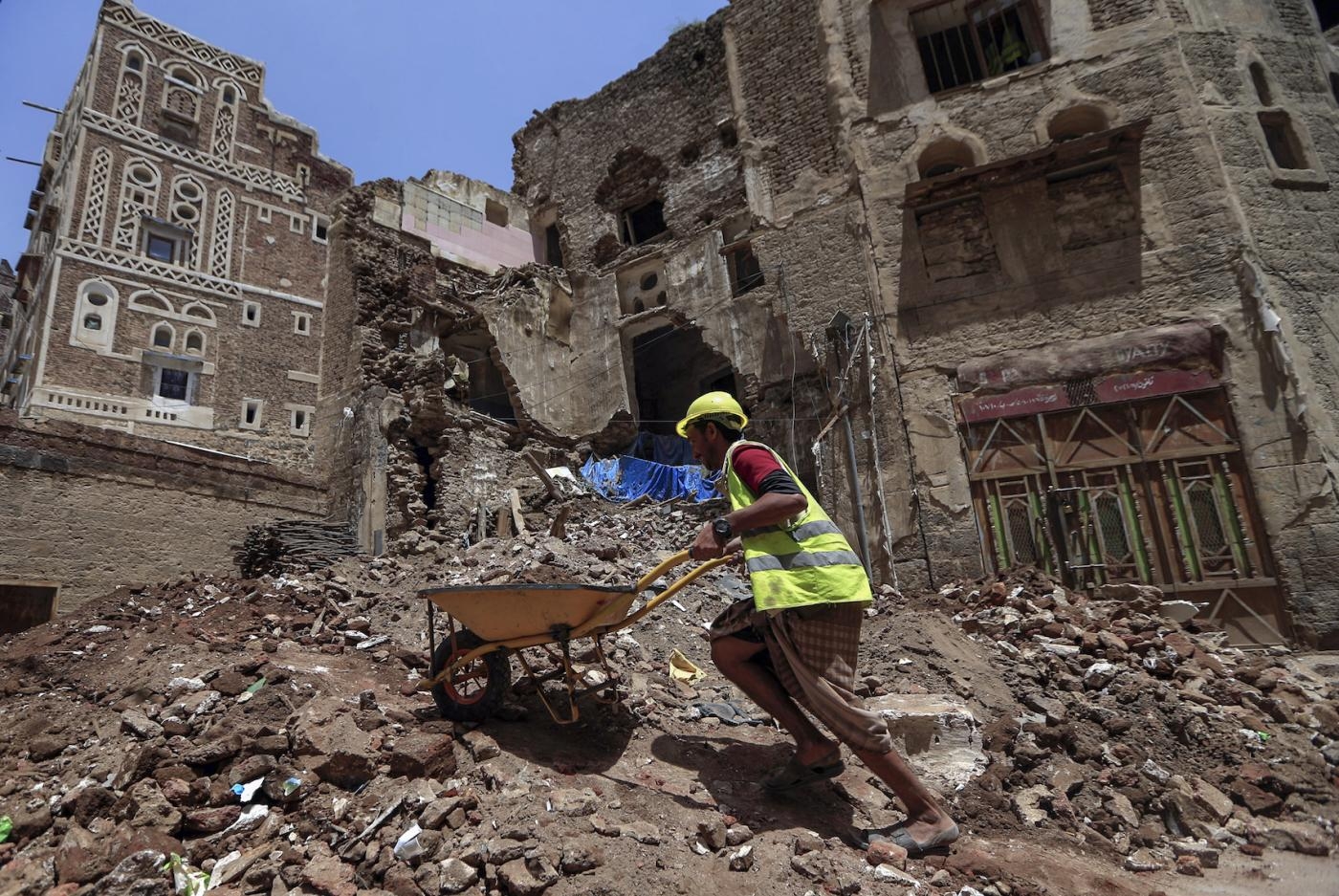 Dans la vieille ville de Sanaa, un ouvrier déblaie les décombres avant le travail de restauration sur le site d’un bâtiment inscrit au patrimoine mondial de l’UNESCO qui s’est effondré à la suite des fortes pluies (AFP)