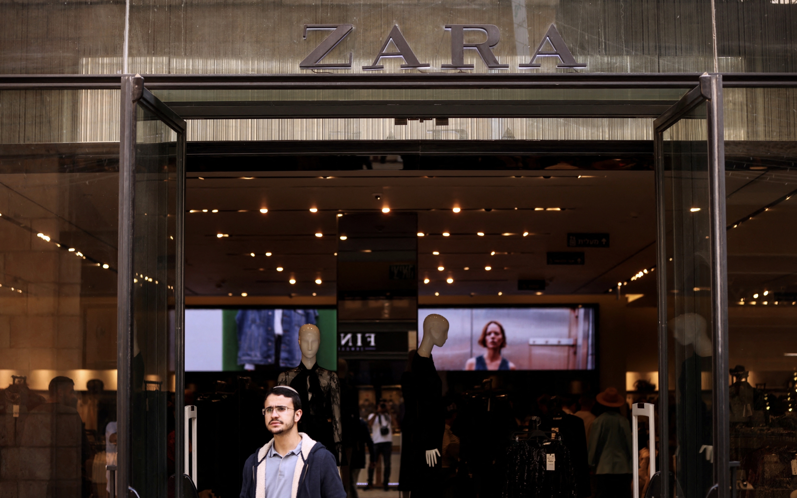 A man leaves a Zara store in a shopping thoroughfare in Jerusalem 24 October 2022 (Reuters)