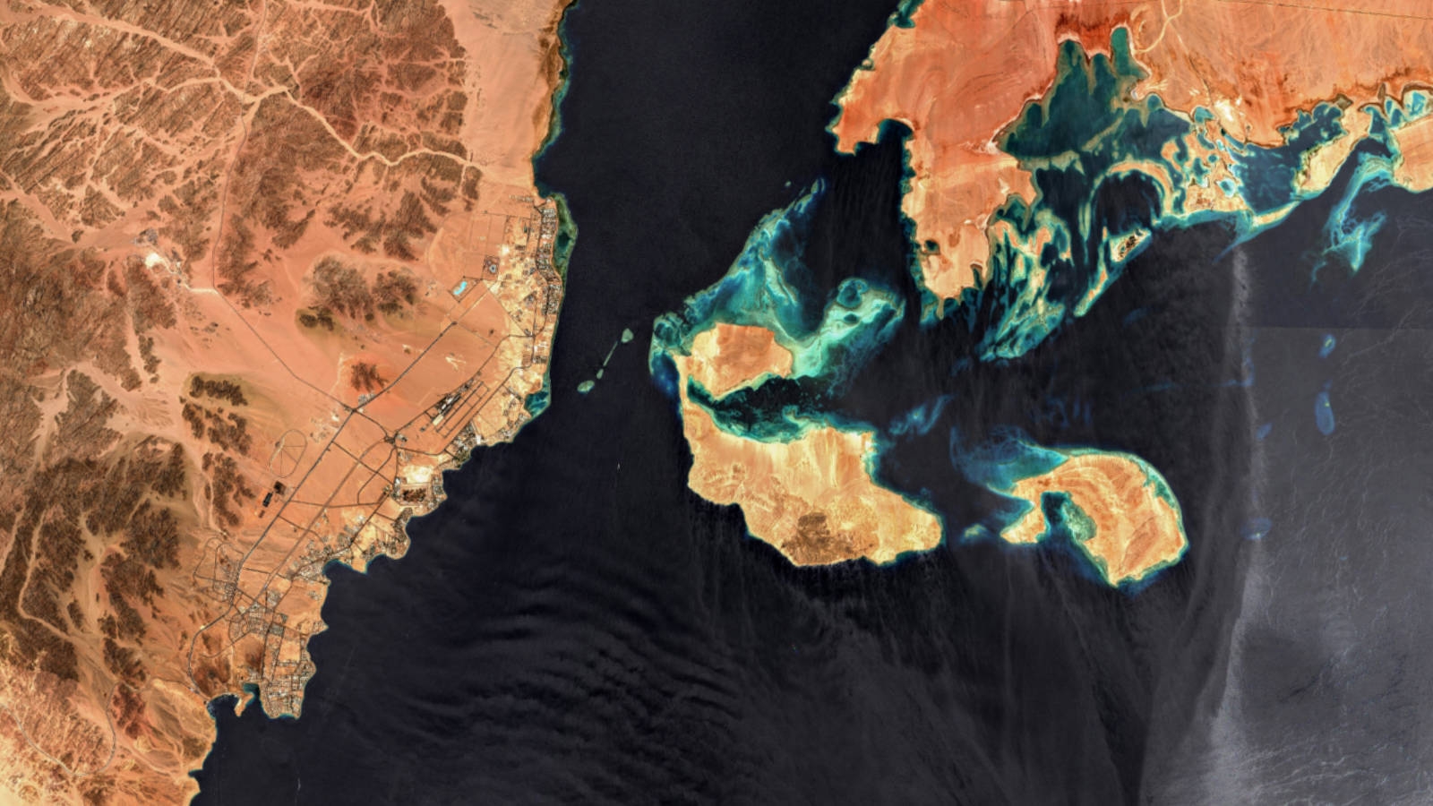 This handout satellite image made available by the European Space Agency and captured by the Copernicus Sentinel-2 mission on July 9, 2022 shows a view of the Strait of Tiran at the mouth of the Red Sea's Gulf of Aqaba (top), with (L to R) the Egyptian Sinai mainland with the Ras Mohamed nature reserve and the city of Sharm el-Sheikh, the islands of Tiran and Sanafir, and the new city of "Neom" currently under construction in the Saudi Arabian mainland.